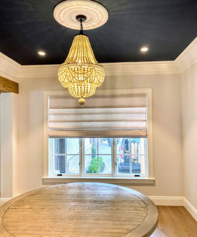 A dining room with a round table and a chandelier hanging from the ceiling. Love is Blinds Arizona (844) 936-2446