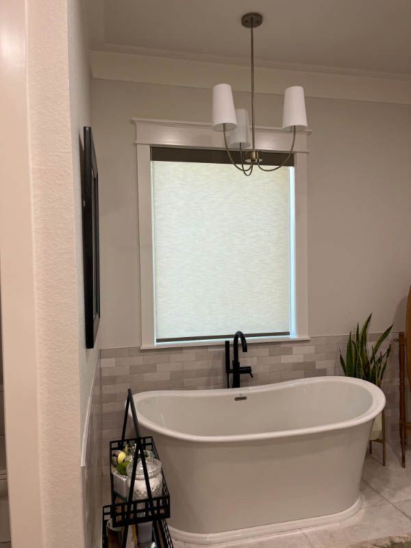 A bathroom with a bathtub and a window. Love is Blinds Arizona (844) 936-2446