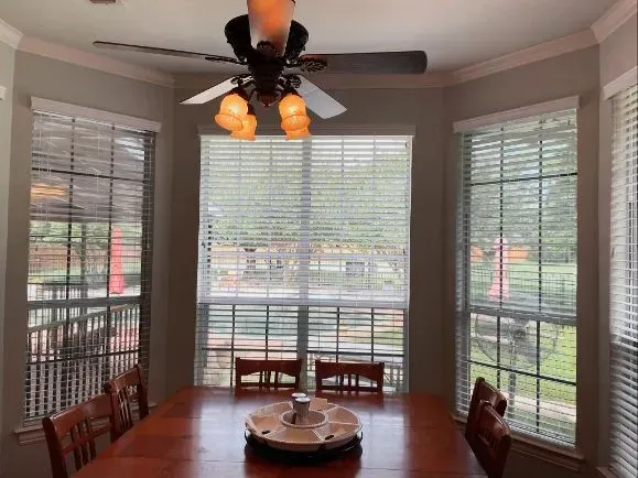 A dining room with a table and chairs and a ceiling fan Love is Blinds Arizona (844) 936-2446