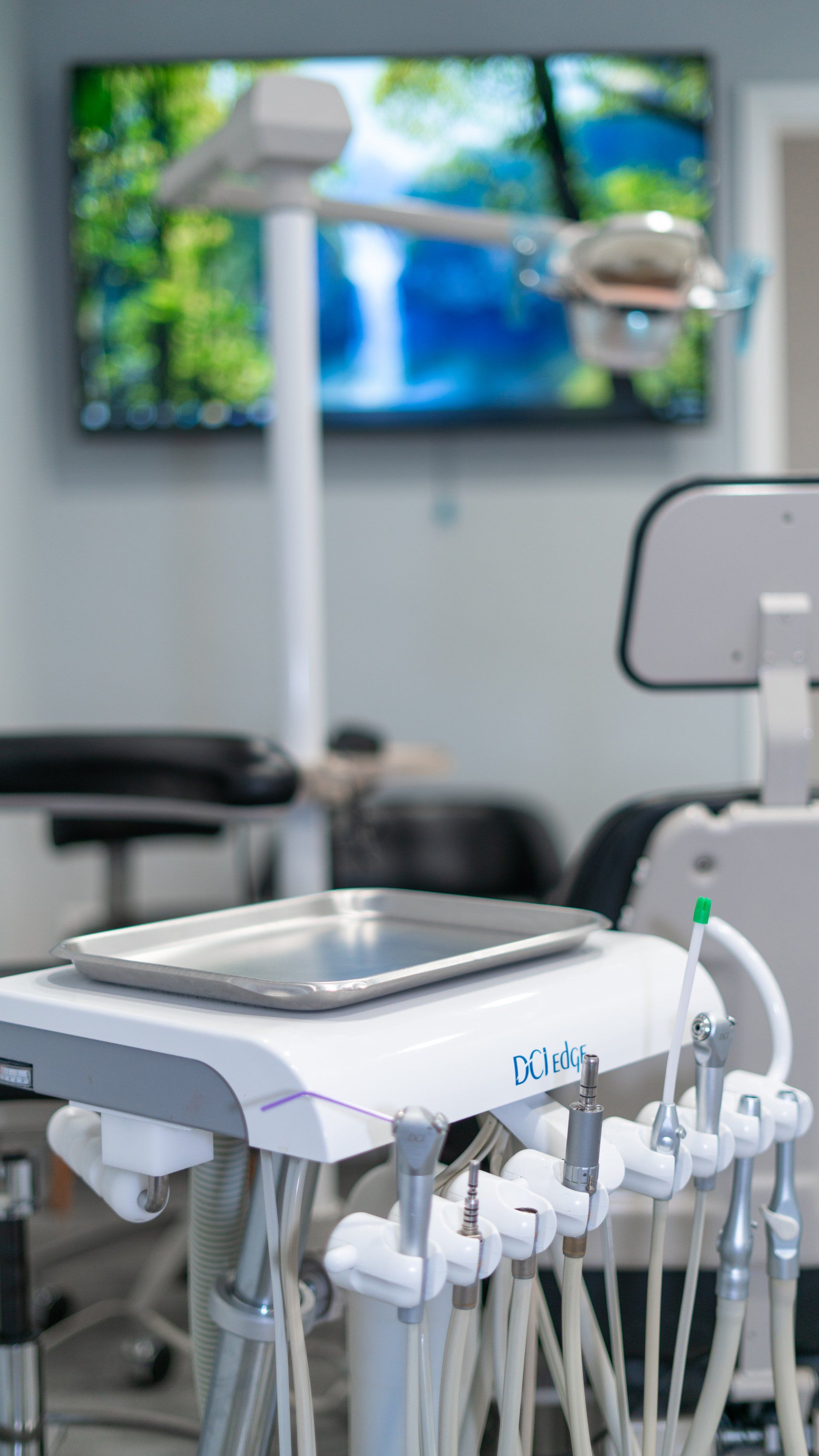 A dental chair with a tray on top of it in a dental office.