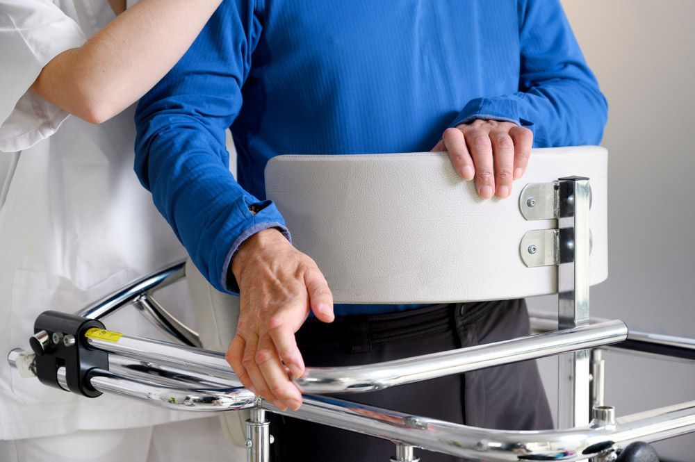 A Woman Is Helping A Man With A Walker — NQ Health In Bayview Heights, QLD