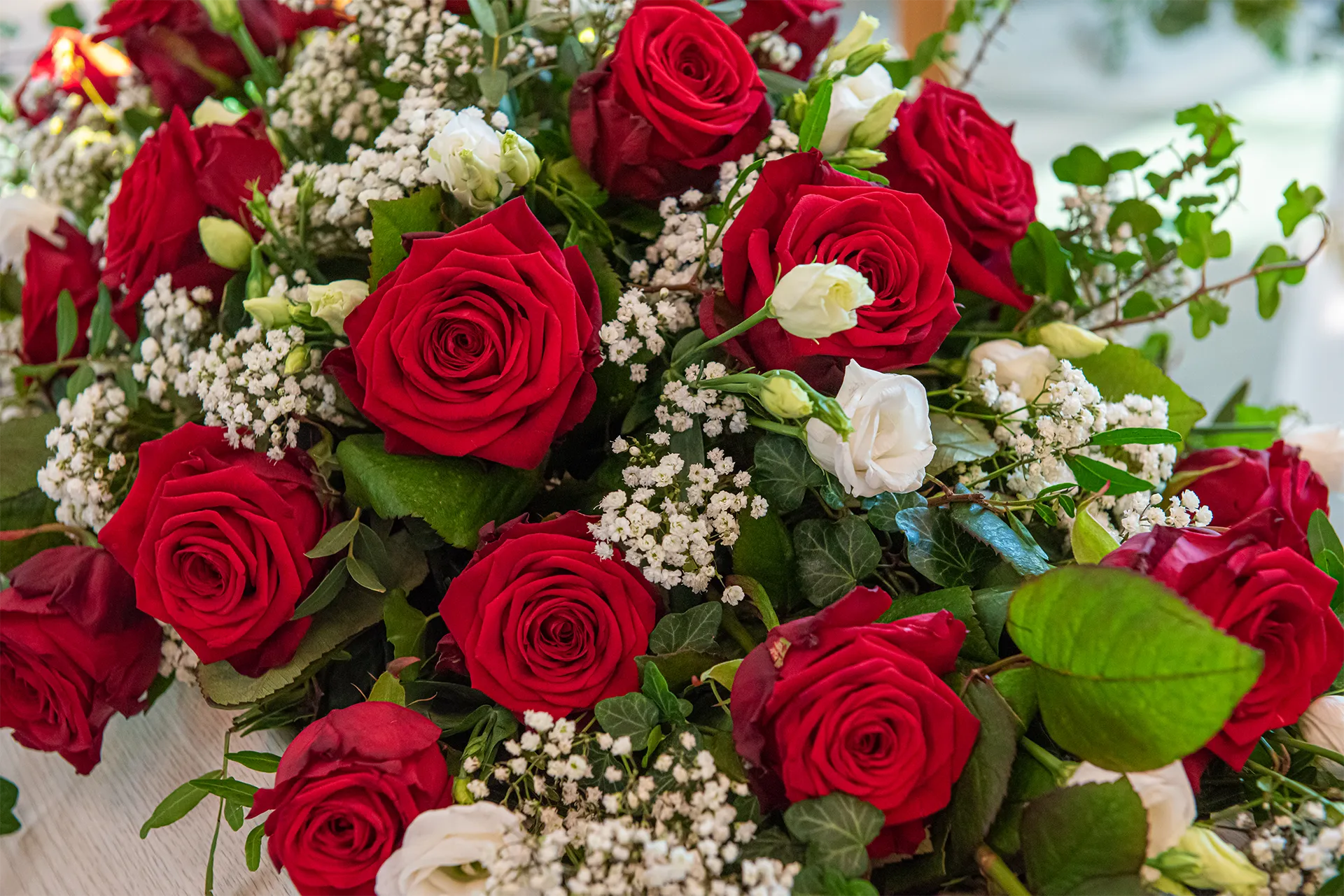 Bouquet of red roses with white baby's breath and green leaves