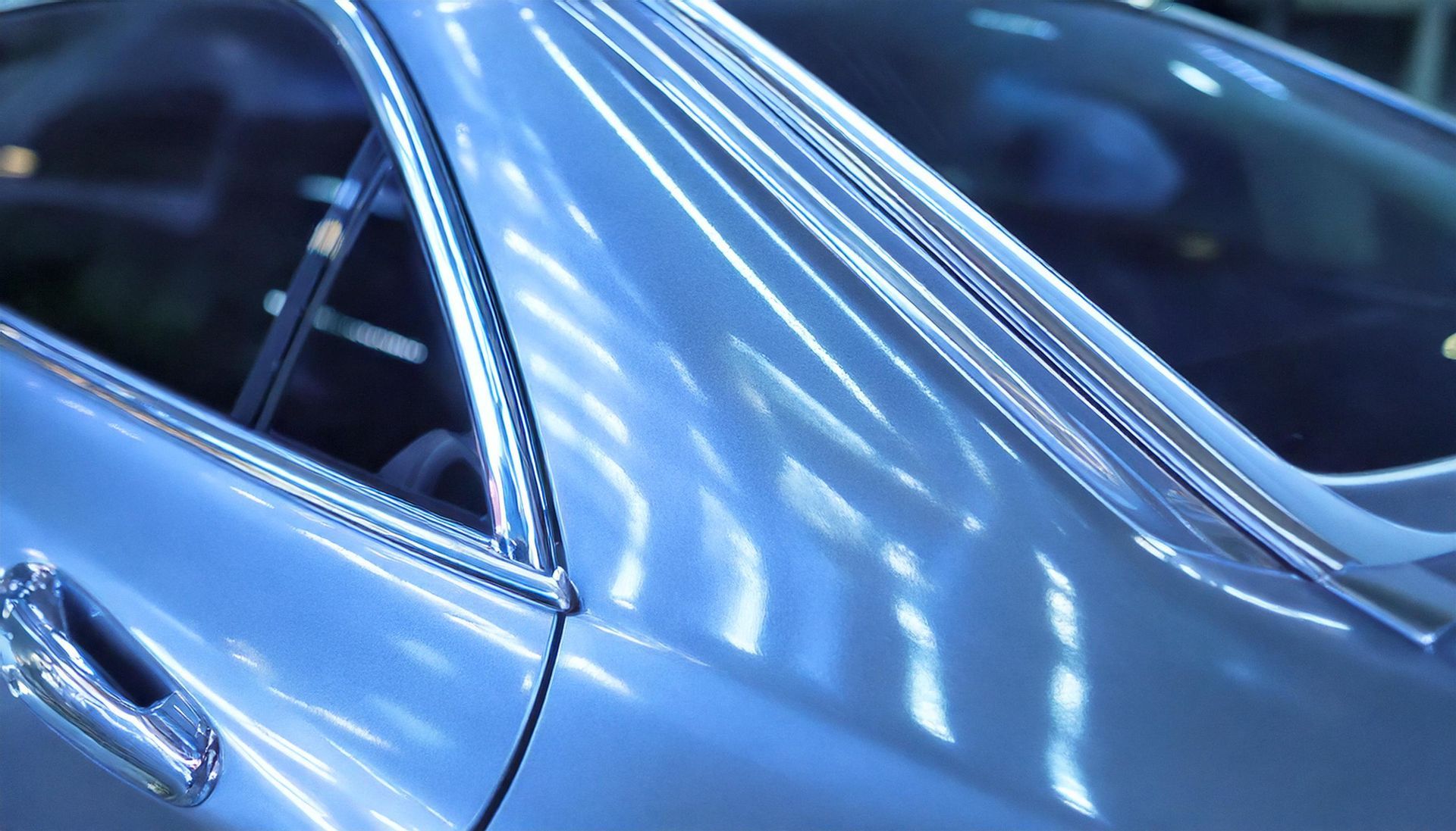 A close up of a blue car with a chrome trim.