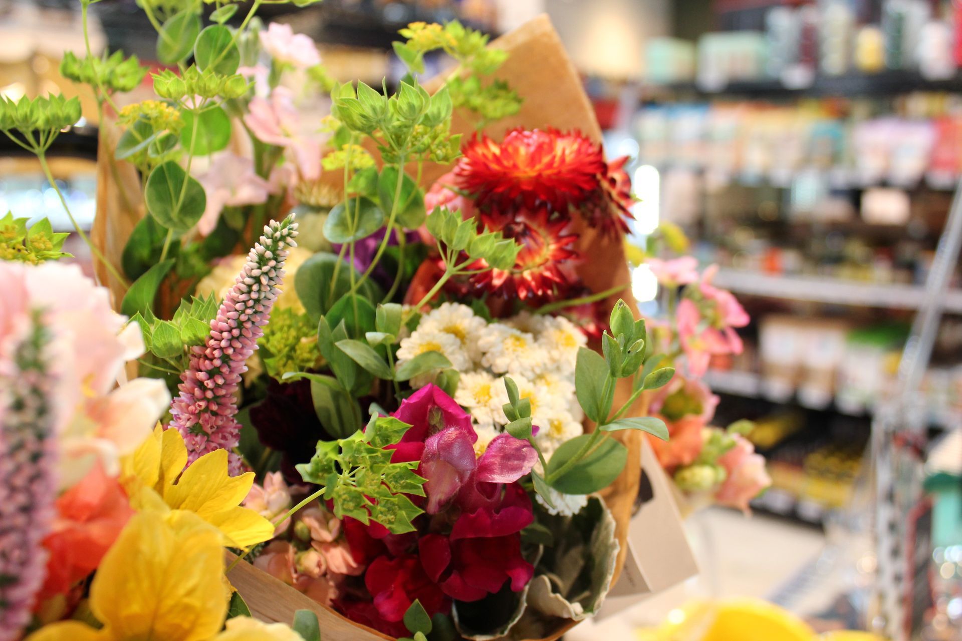 A bouquet of flowers is sitting on a table in a grocery store.