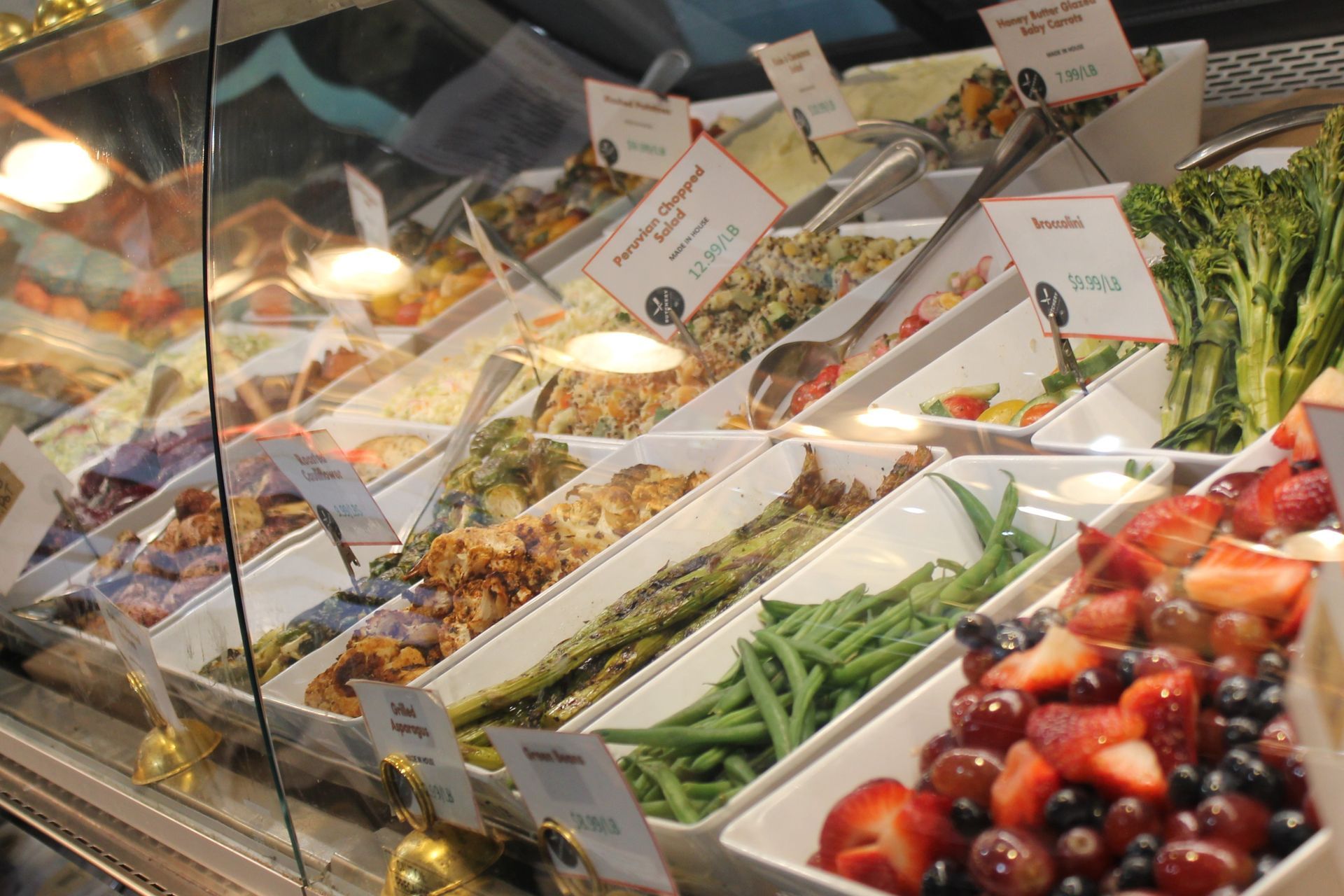 A display case filled with a variety of vegetables and fruits