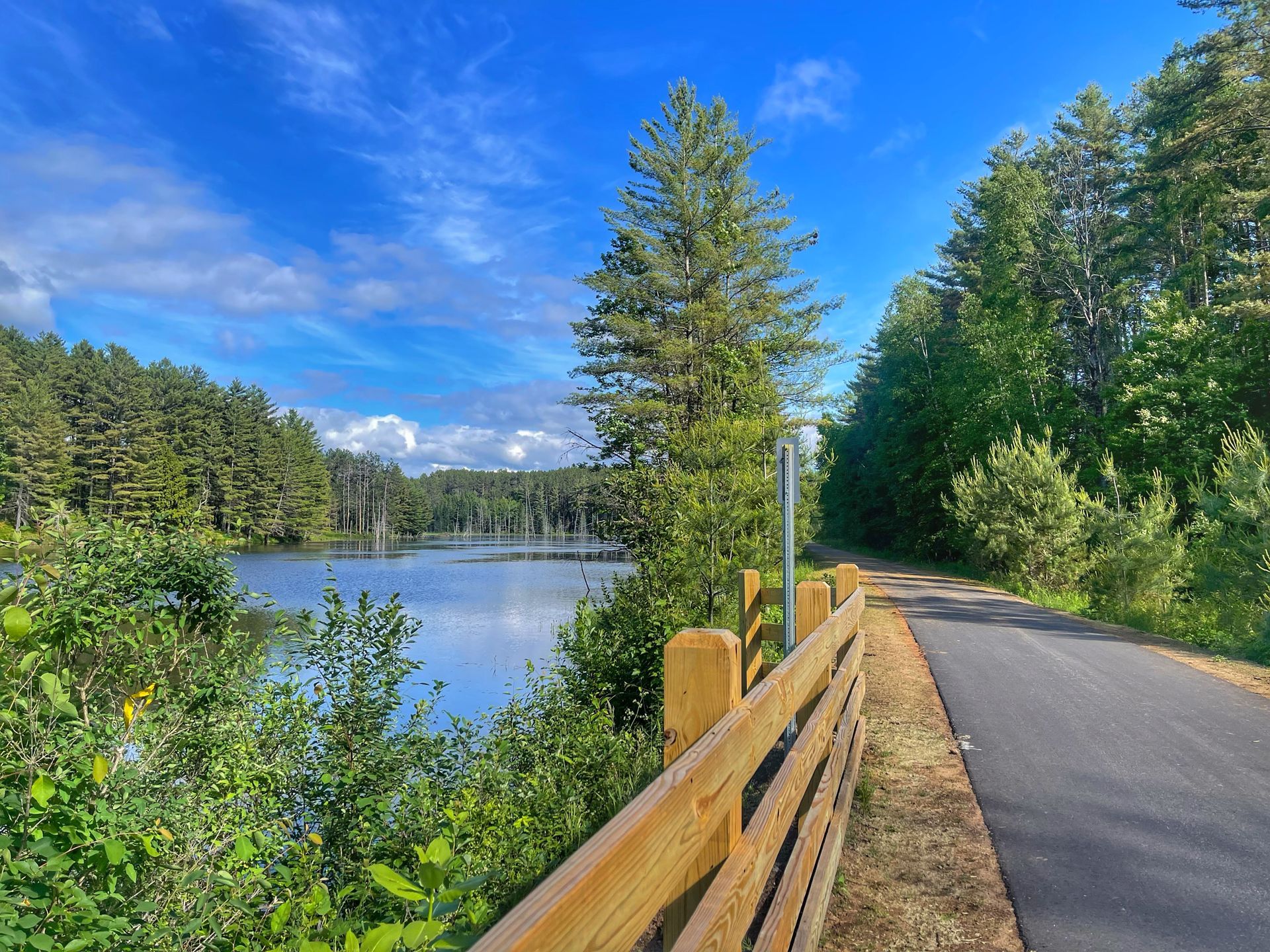 View of Adirondack Rail Trail bike path and lake