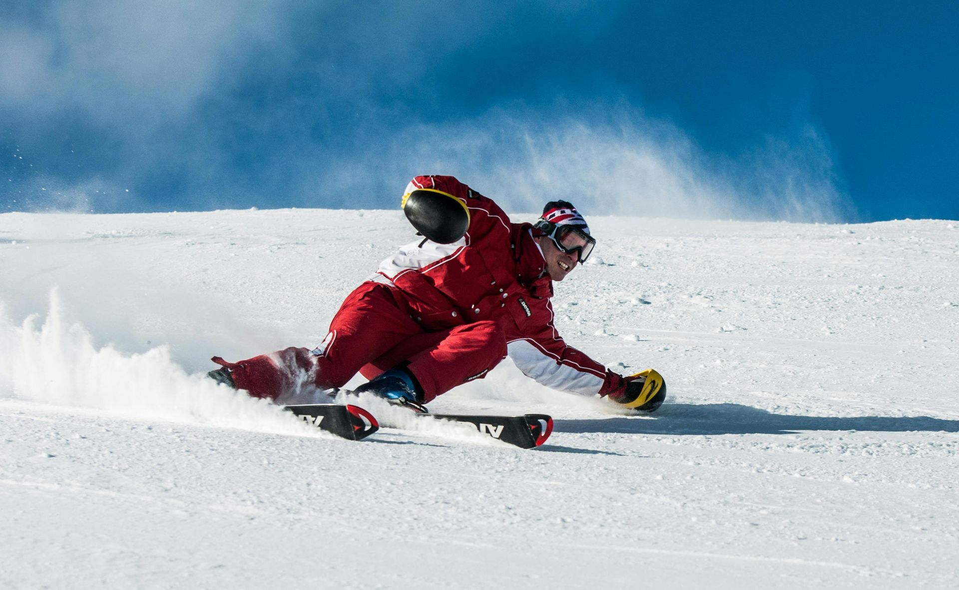 Skiier heading down the ski slope on a clear, sunny day
