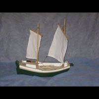 a small model sailboat is floating on top of a blue surface .