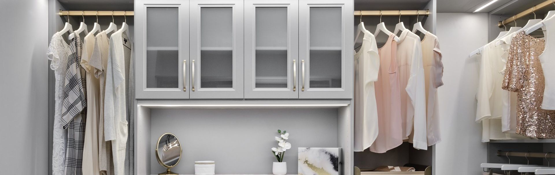 A walk in closet filled with lots of clothes and a mirror.