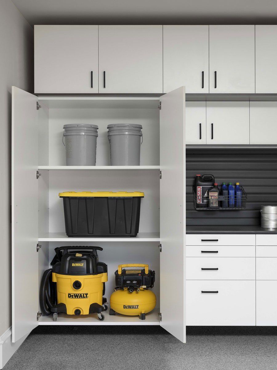 a garage cabinet system with open doors displaying the shelving inside .