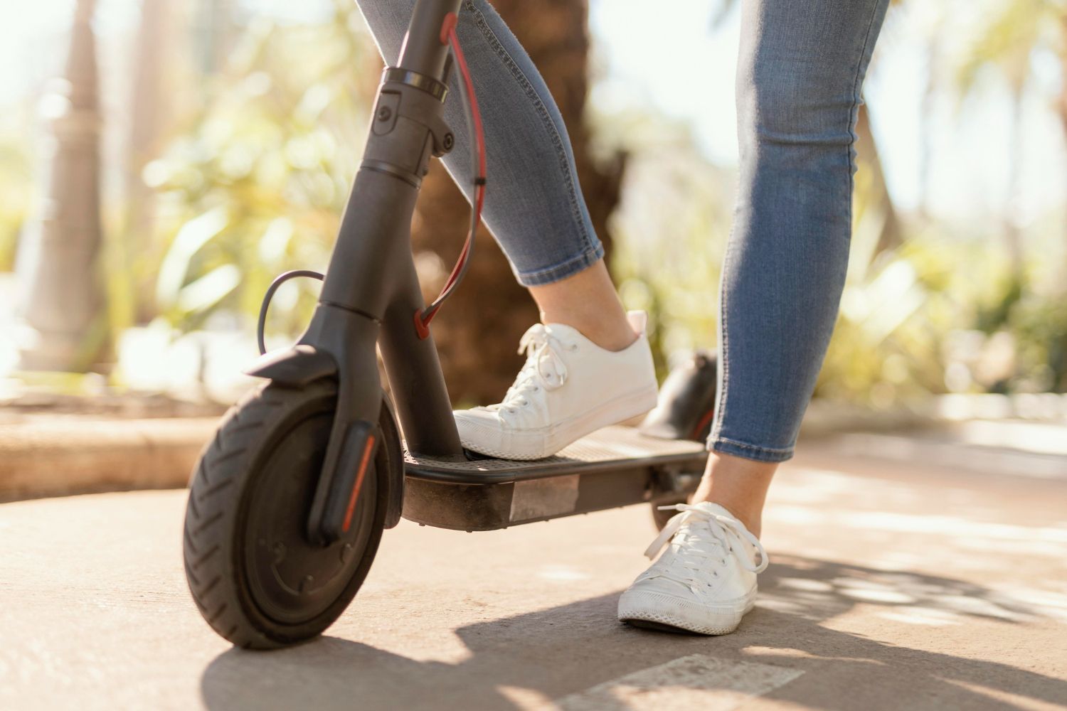 A woman is riding an electric scooter down a street.