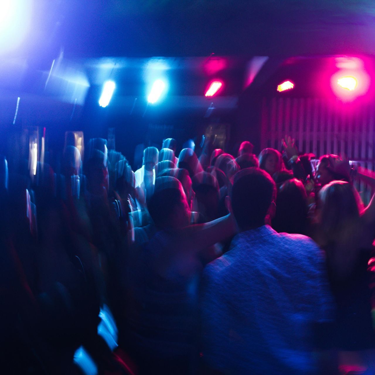 A crowd of people are dancing in a dark room