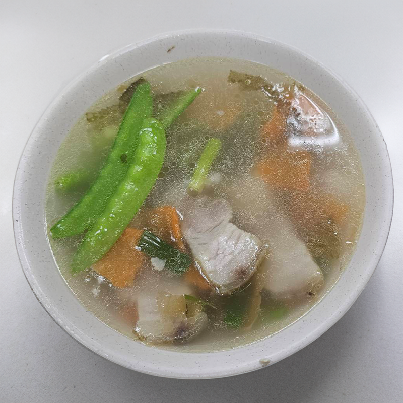一碗清湯，裡面有豬肉、四季豆和胡蘿蔔。