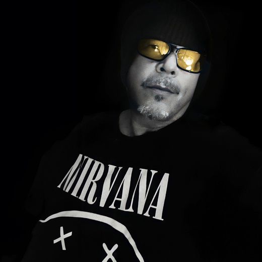 A man wearing sunglasses and a nirvana shirt