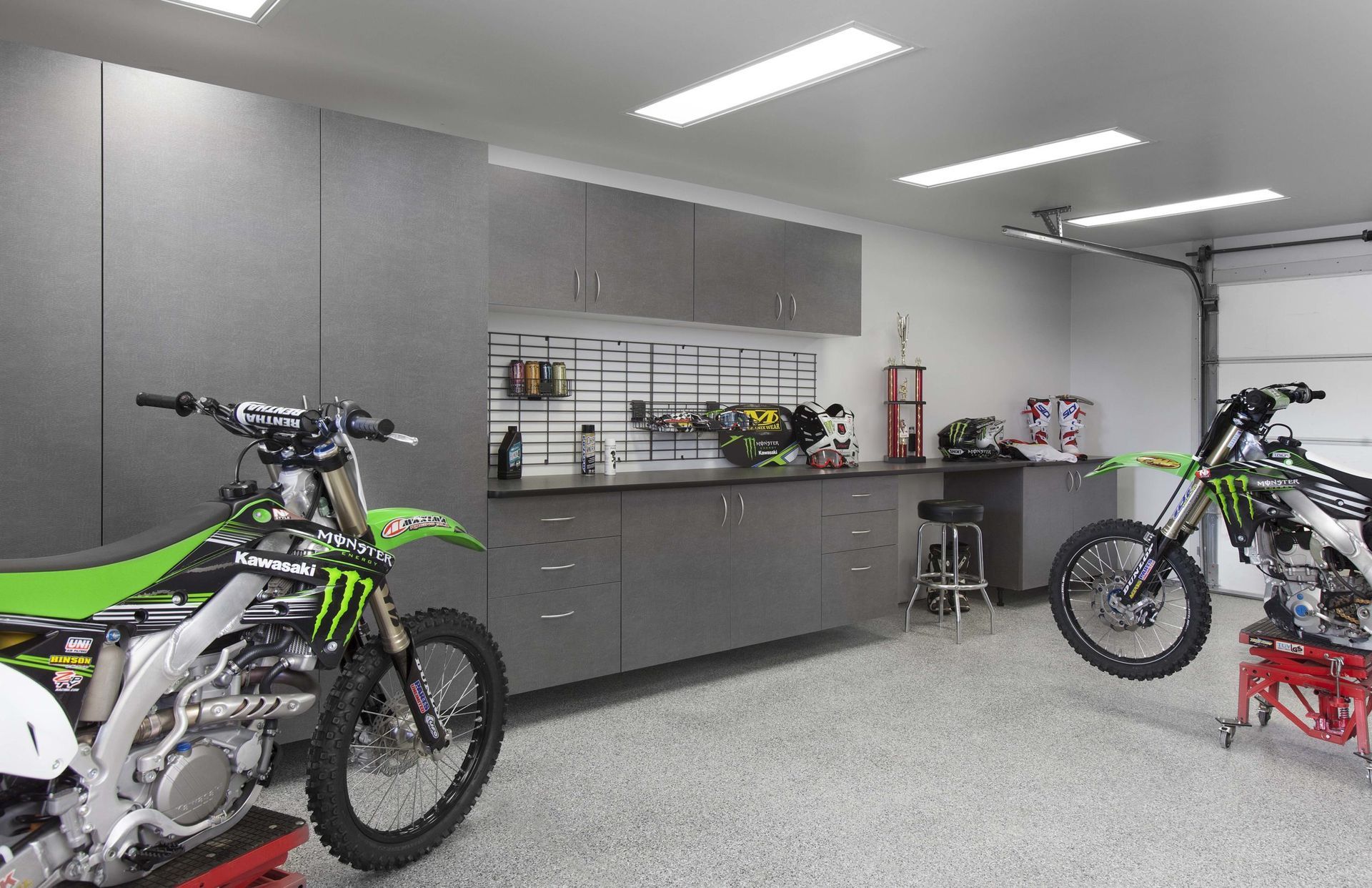 a garage with lots of white cabinets and drawers