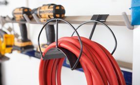 a red cord is hanging on a hook in a garage .