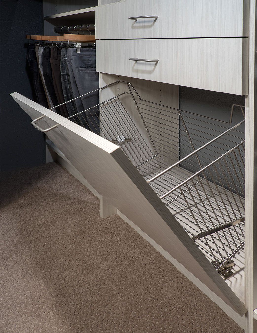 a laundry basket is pulled out of a closet