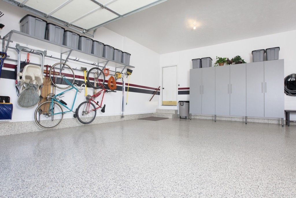 a large garage with epoxy garage floor coating, cabinets, and shelving .