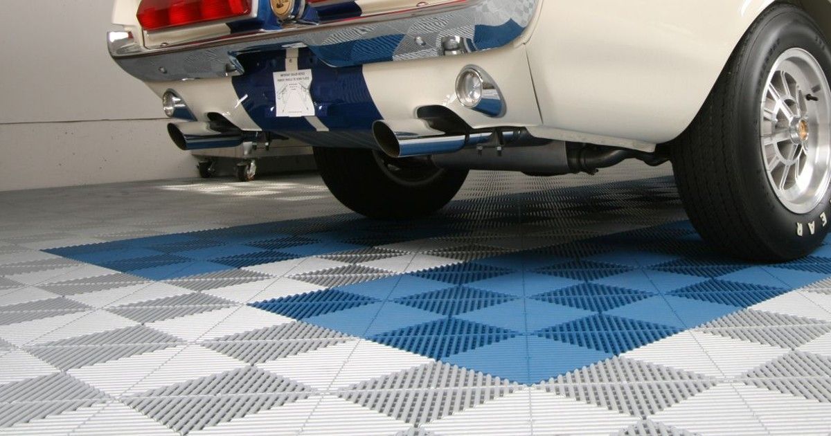A blue and white mustang is parked in a garage