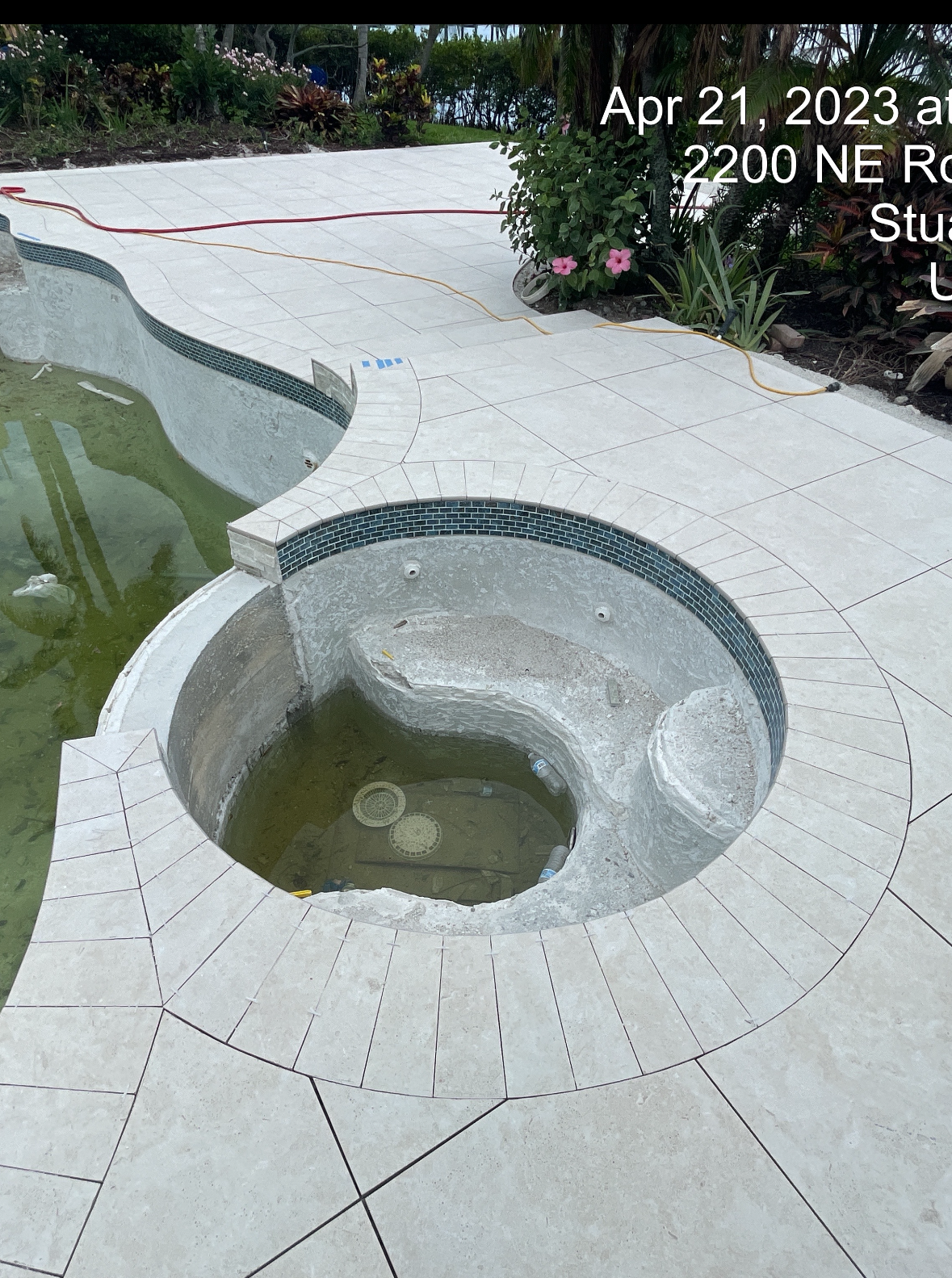 A swimming pool with a hot tub in the middle of it