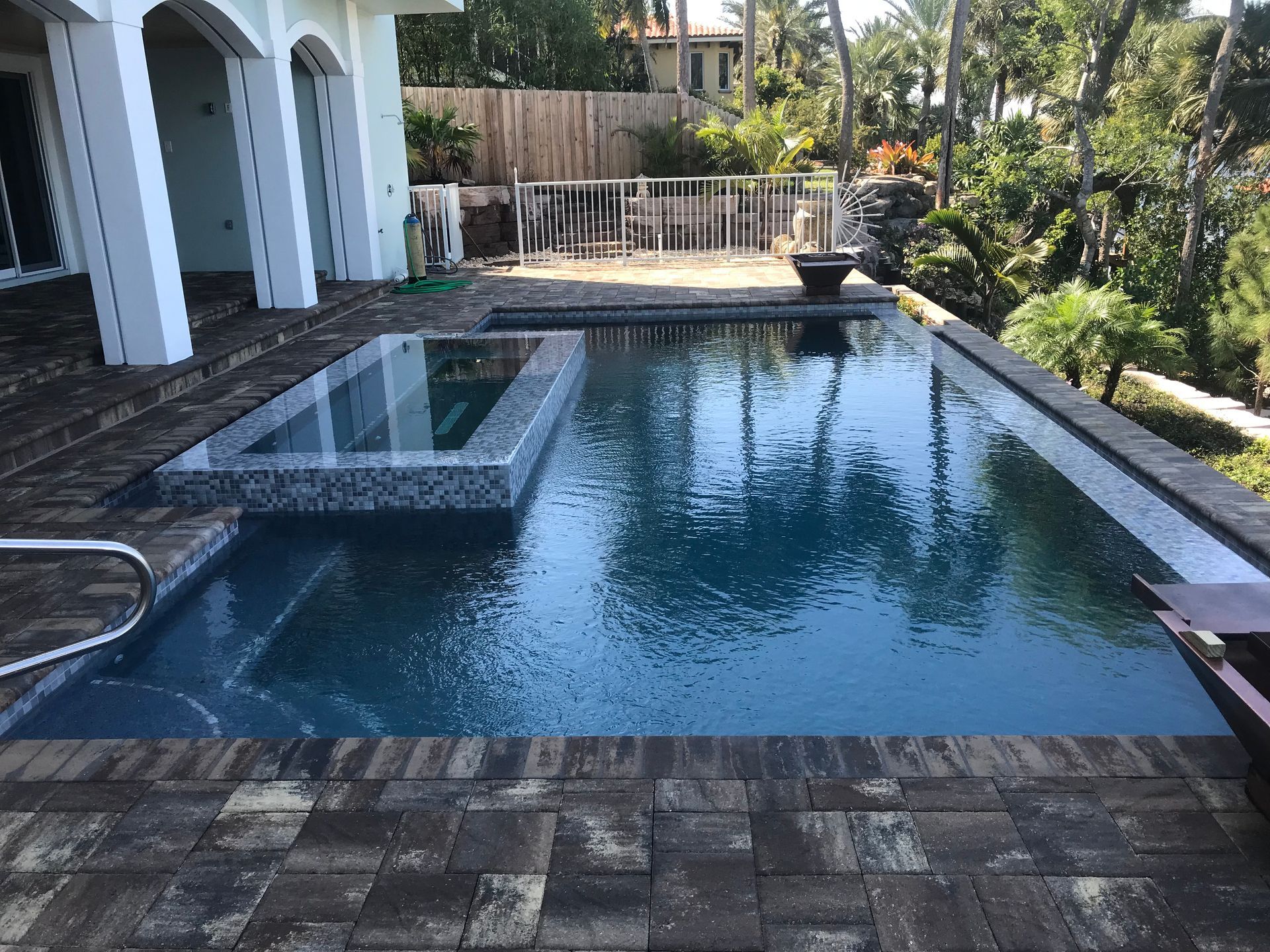 There is a large swimming pool in the backyard of a house.
