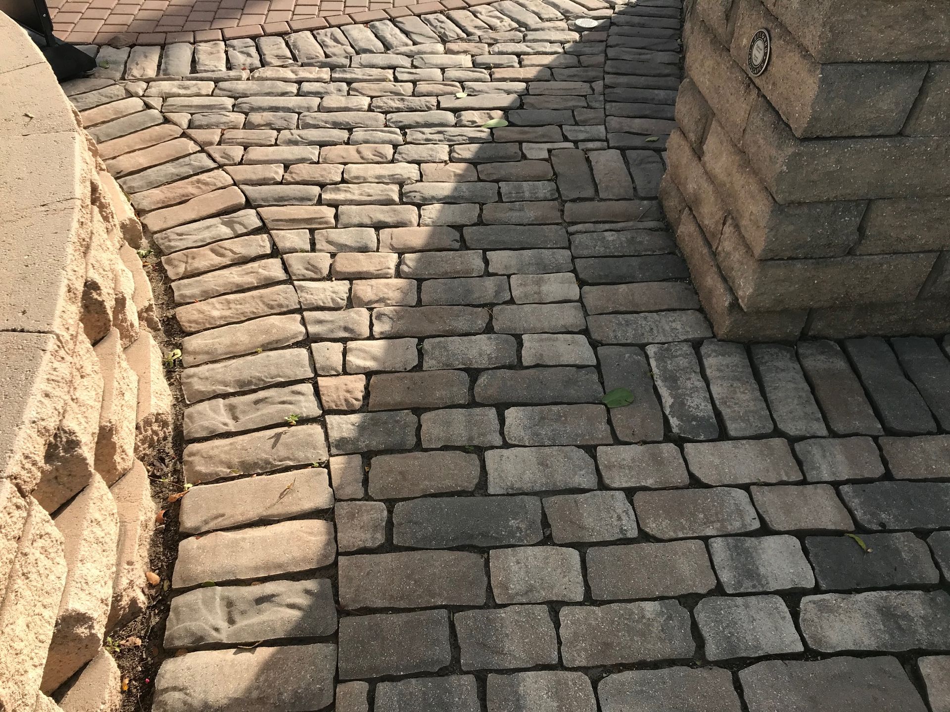 A brick walkway with a brick wall in the background