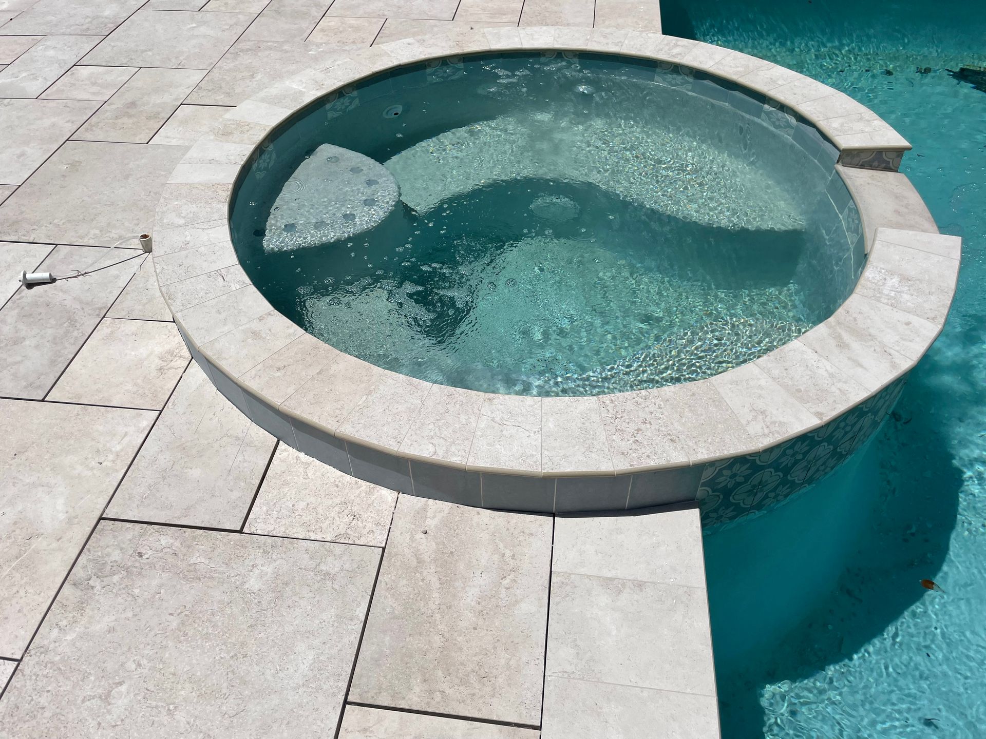 A pool with a hot tub in the middle of it