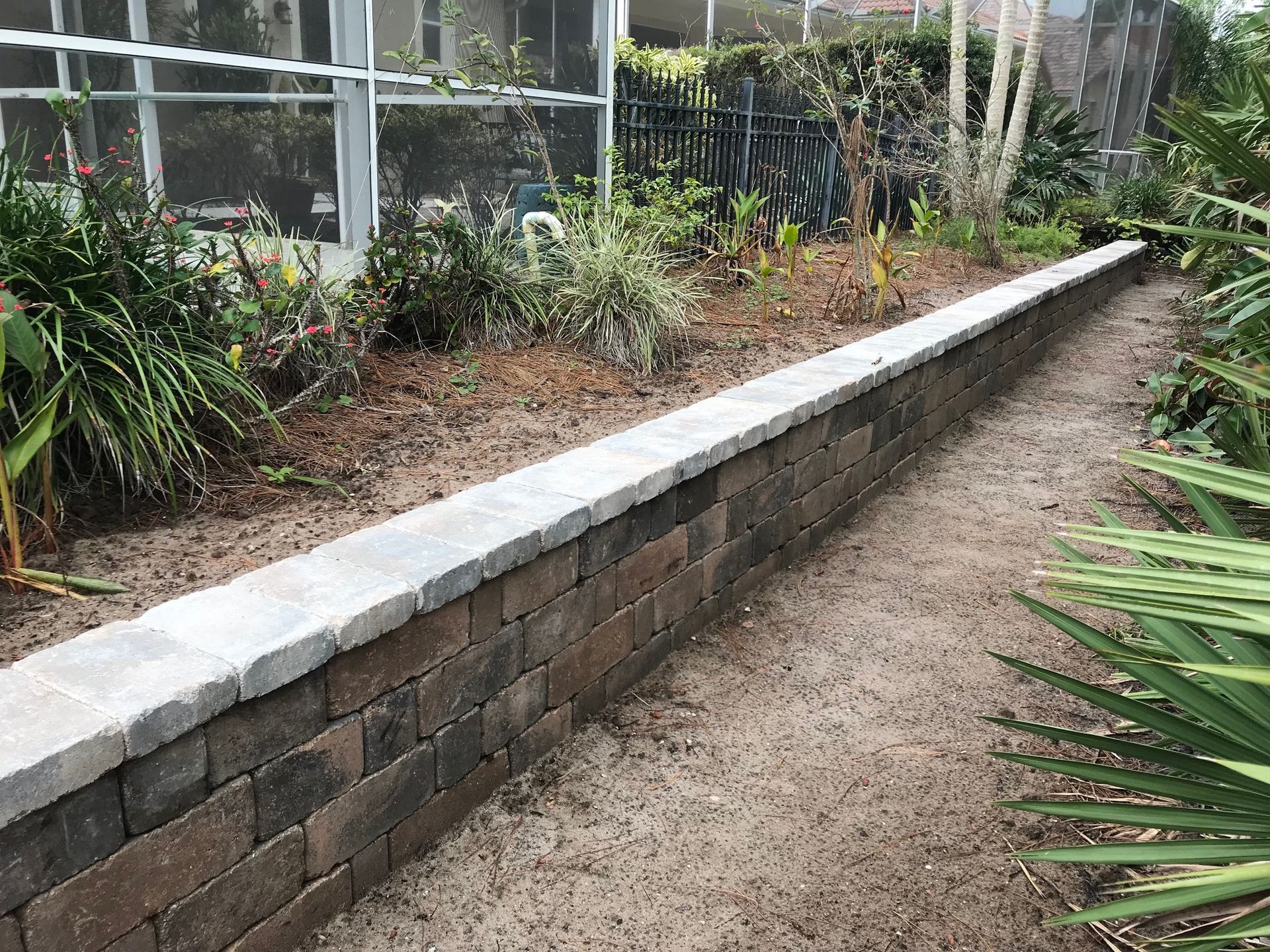 There is a brick wall in the middle of a garden.