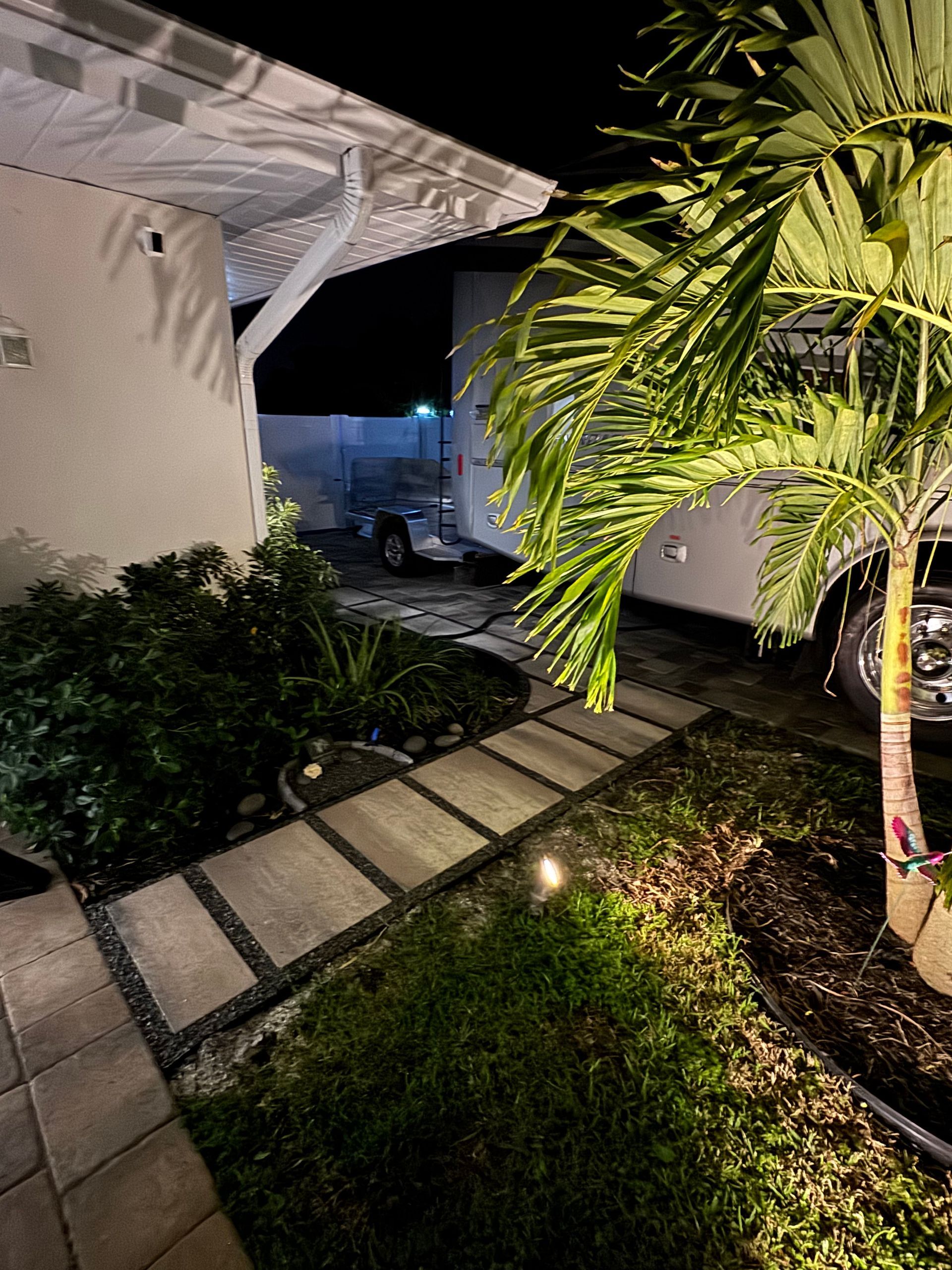 A car is parked in front of a house at night.