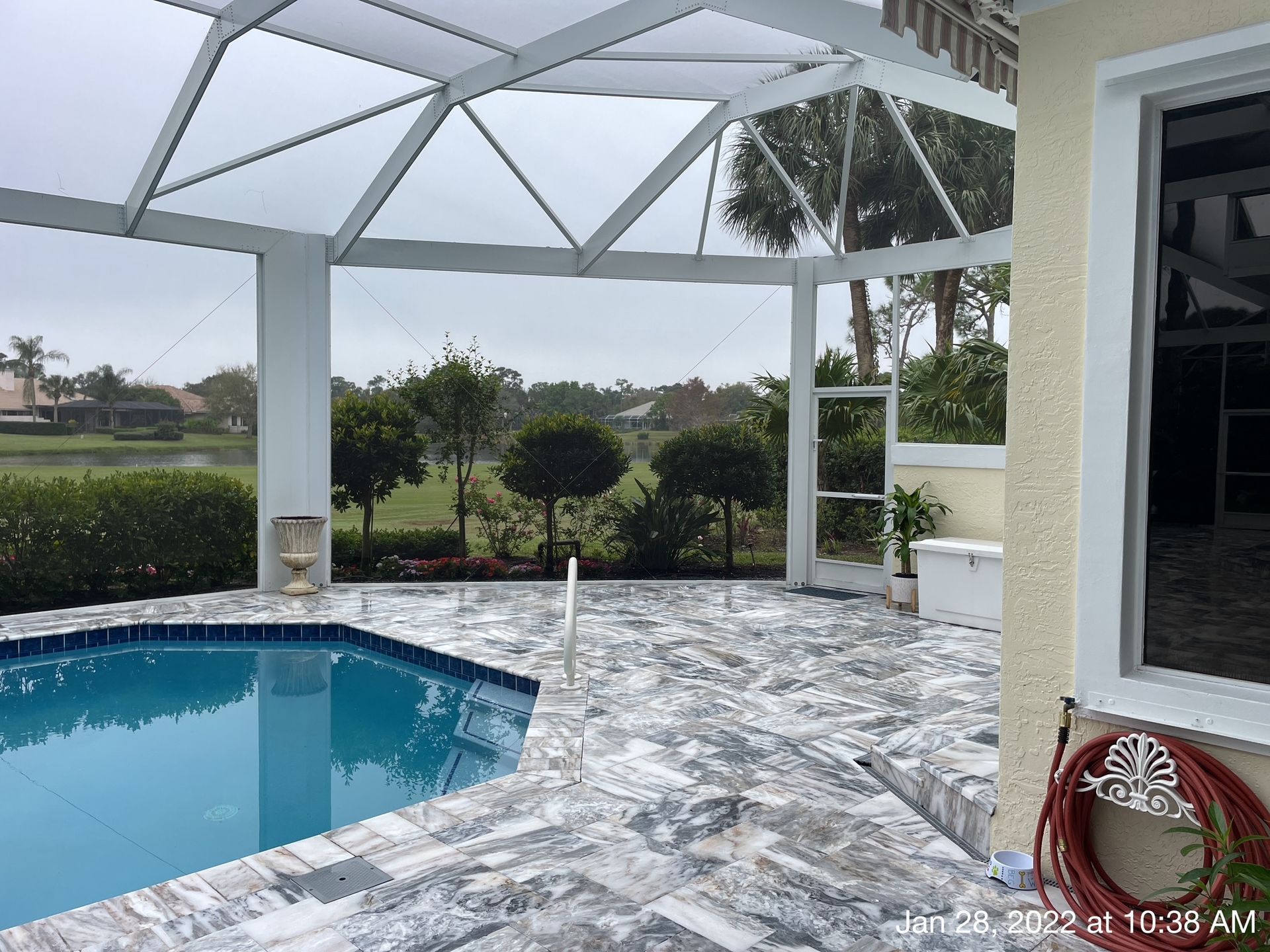 A swimming pool with a screened in area in front of it