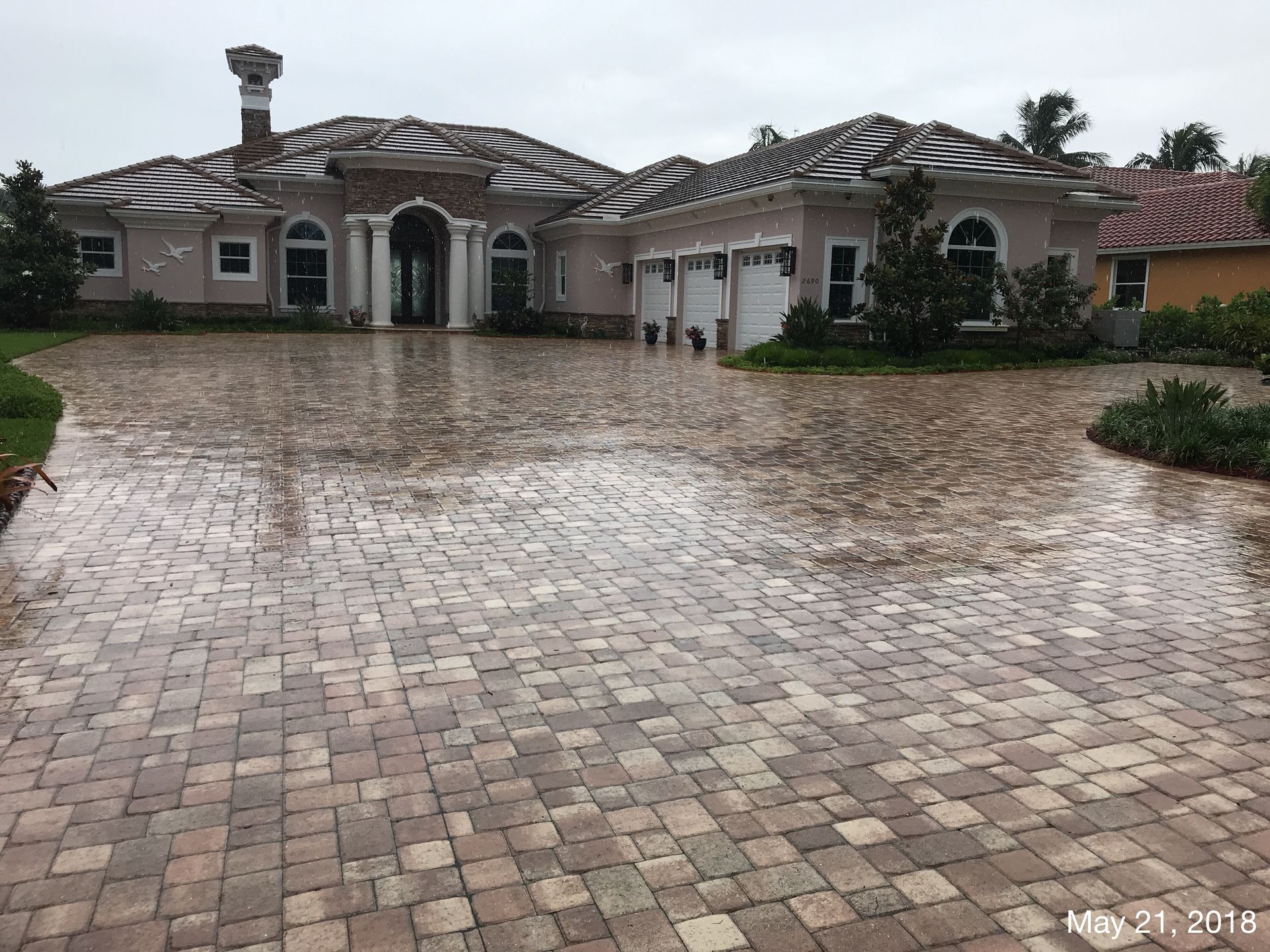 A large house with a brick driveway in front of it