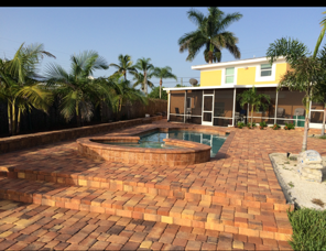 A yellow house with a swimming pool in front of it