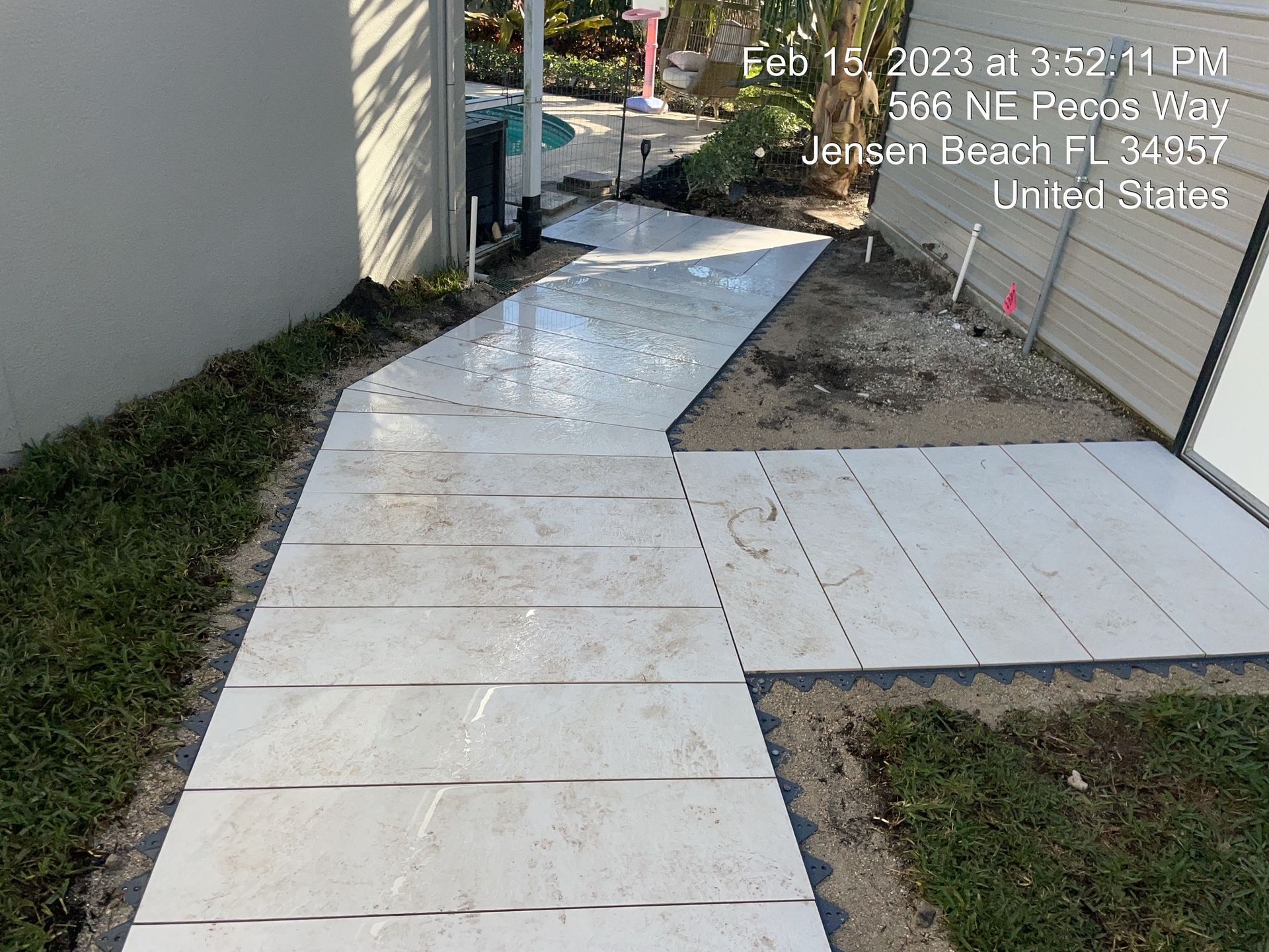 A walkway is being built in the backyard of a house.