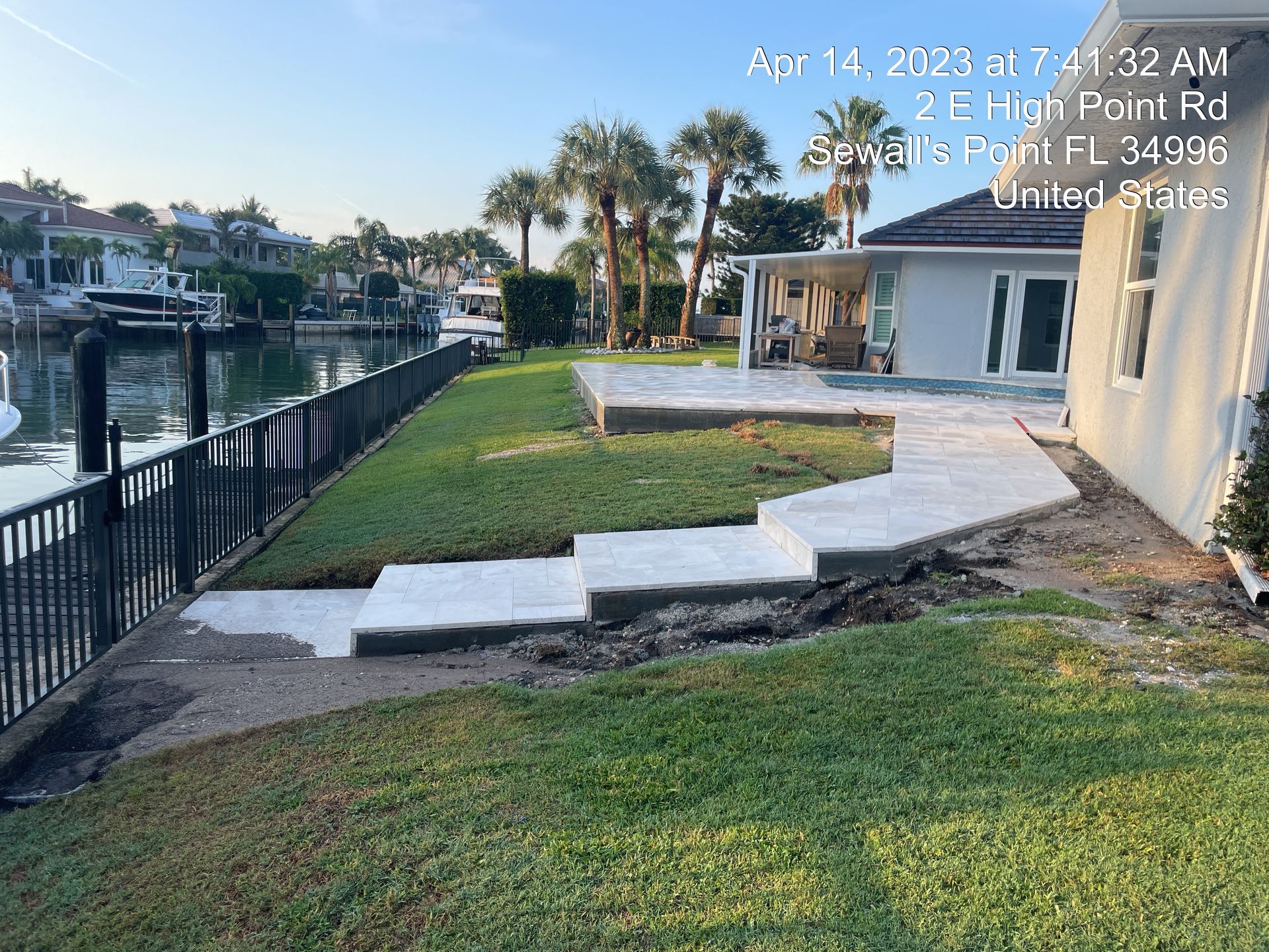 A concrete walkway is being built in front of a house next to a body of water.