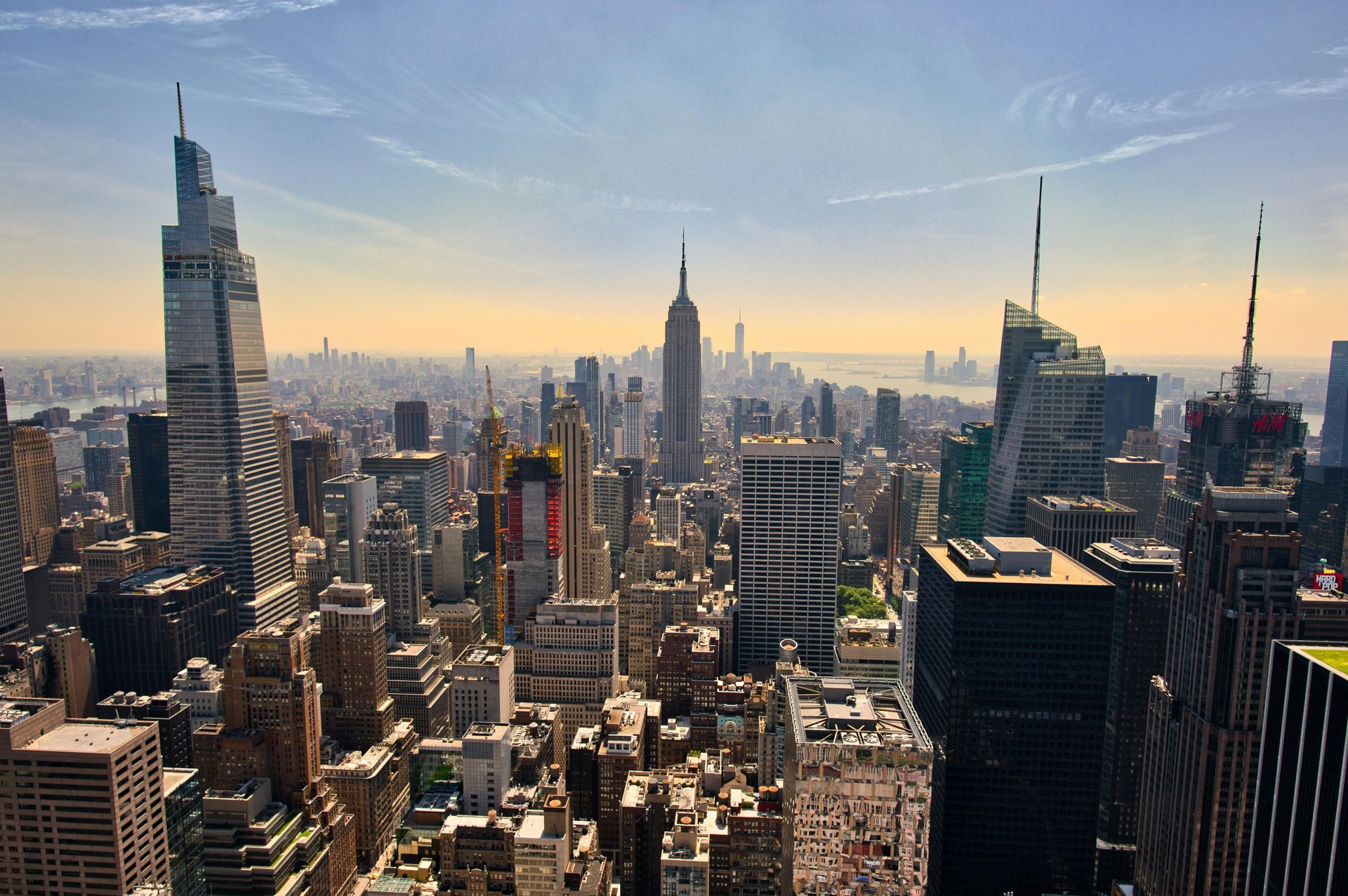 New York City skyline at sunset, with the Empire State Building and tall skyscrapers.