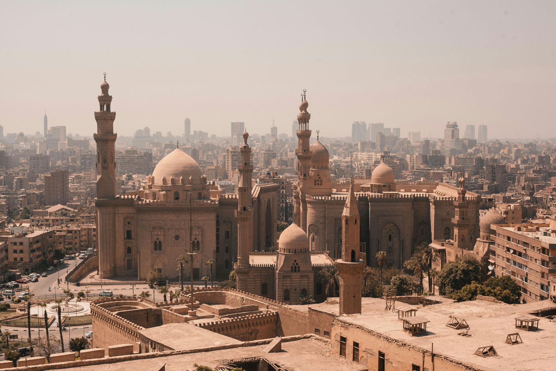Historic mosque complex and minarets rising over a dense city skyline in hazy daylight