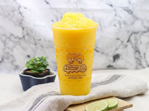 Clear plastic cup of layered iced coffee with a yellow lid on a white table