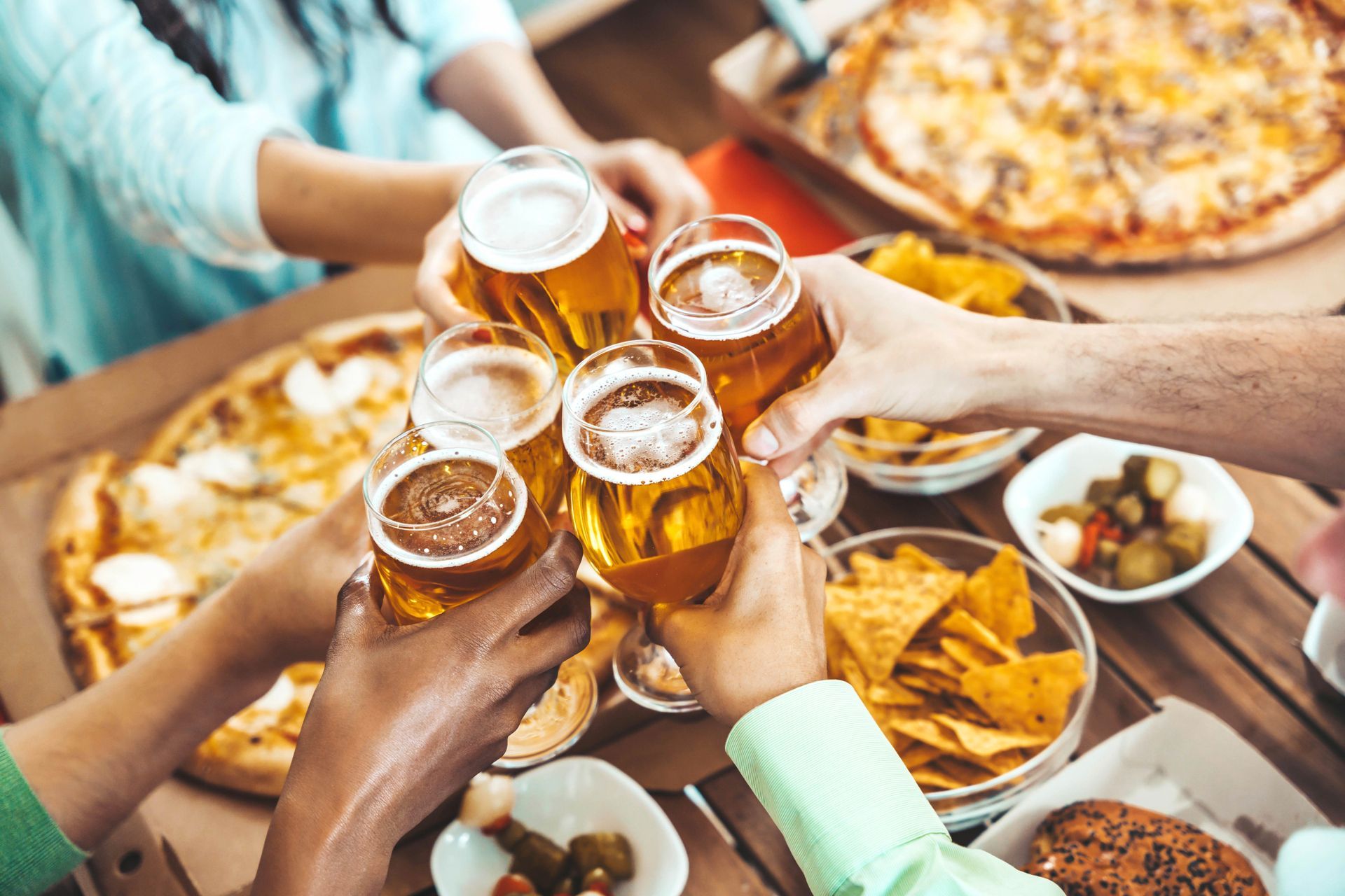 Friends toasting beers around a table