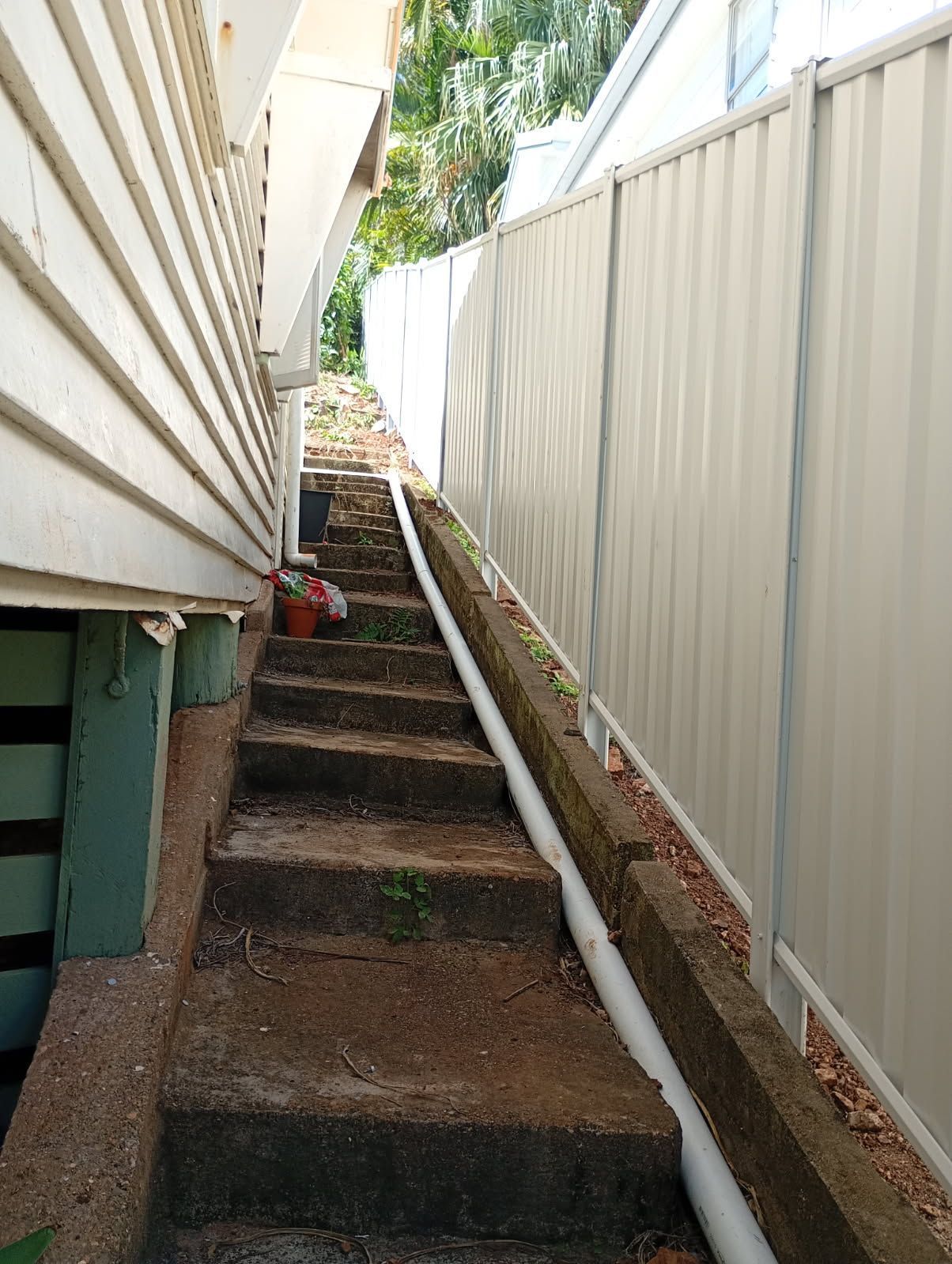 Concrete Stairs Between a White-sided Building and a White Fence — The Fence Place in Kawana, QLD