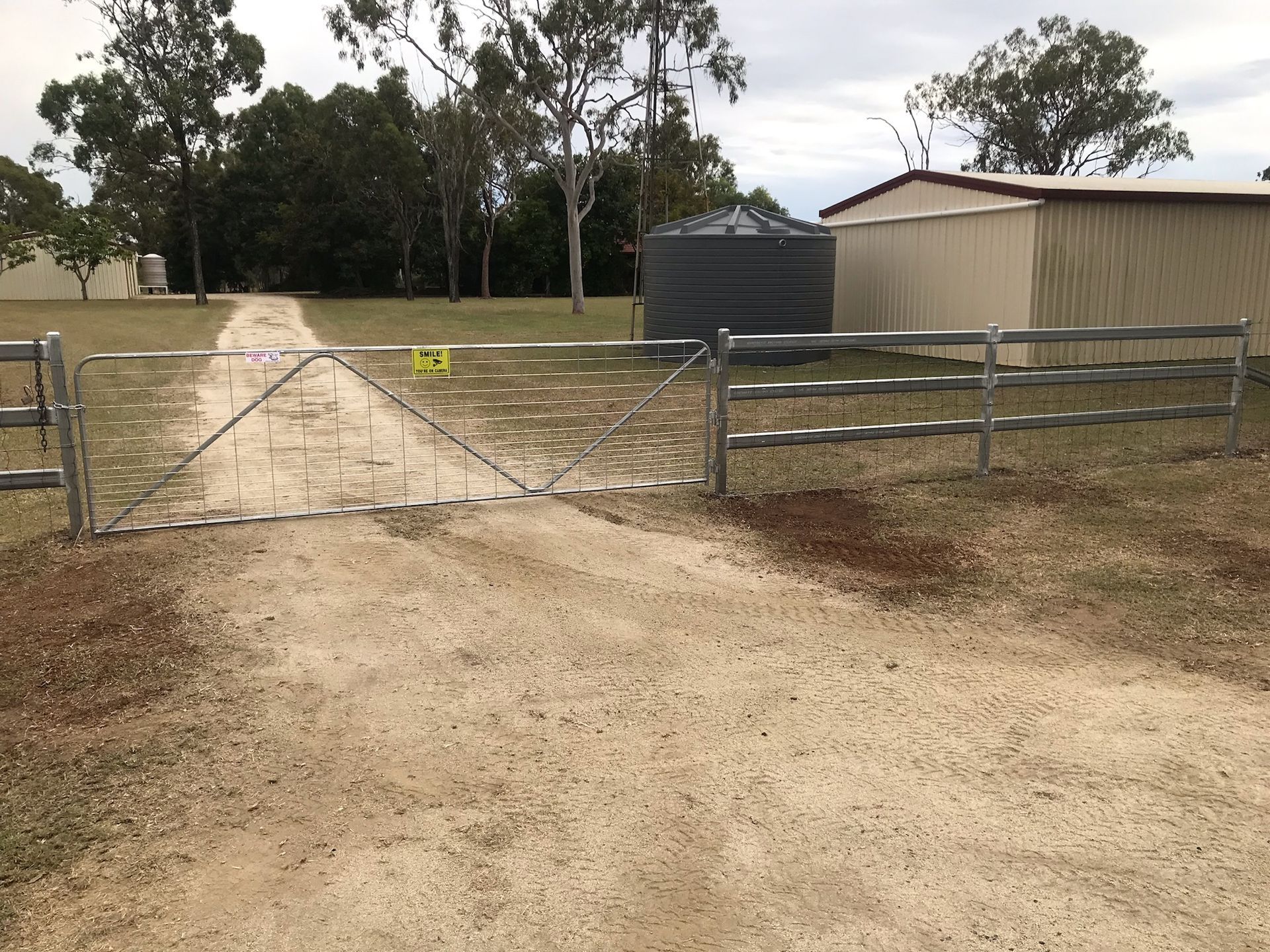 Gravel Driveway With Metal Gate and Fence — The Fence Place in Kawana, QLD