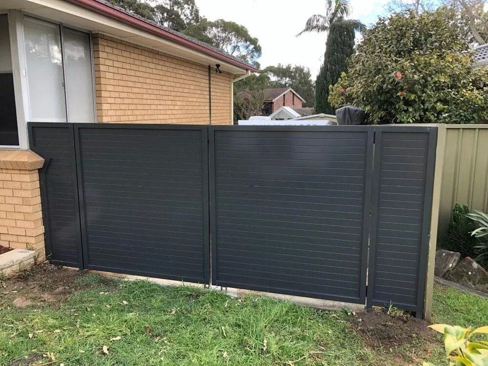 Dark Gray Horizontal Slat Fence Next to a Brick House and a Green Lawn — The Fence Place in Kawana, QLD