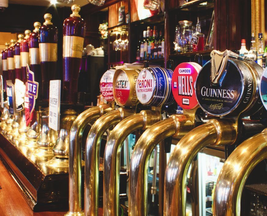 A row of beer taps with one that says guinness on it