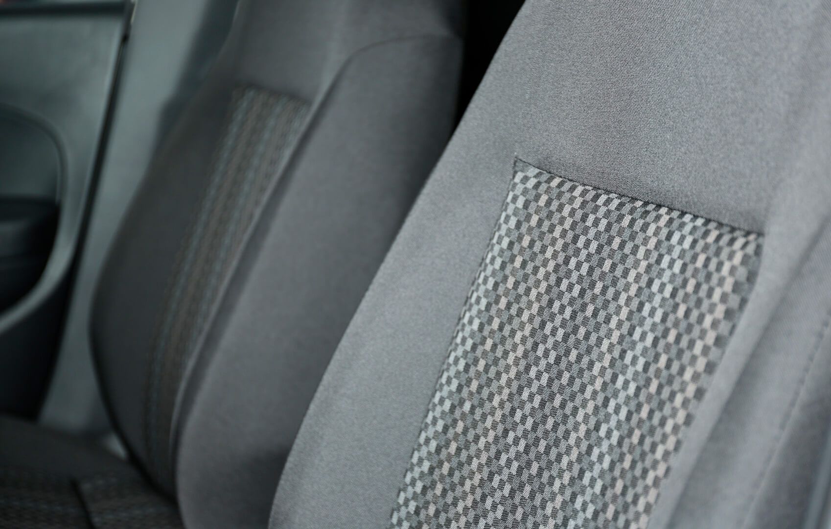 Vista de cerca de los asientos de un automóvil de color gris oscuro con una tela texturizada