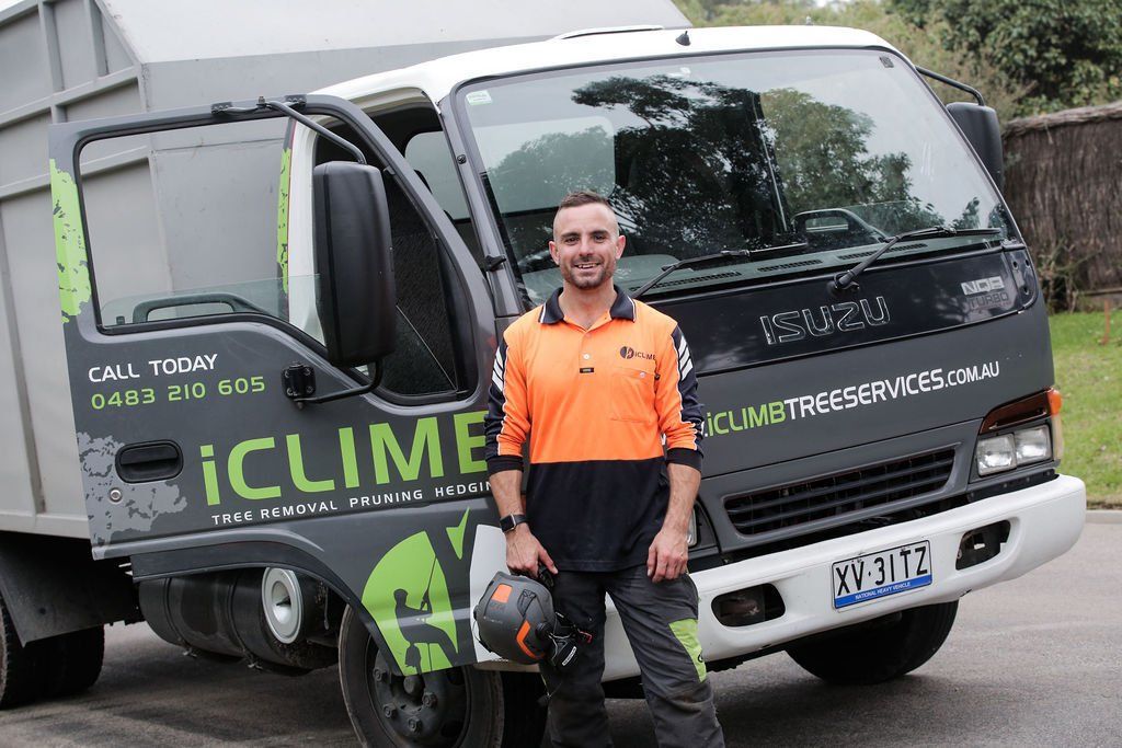 A man is standing in front of a truck that says iclime