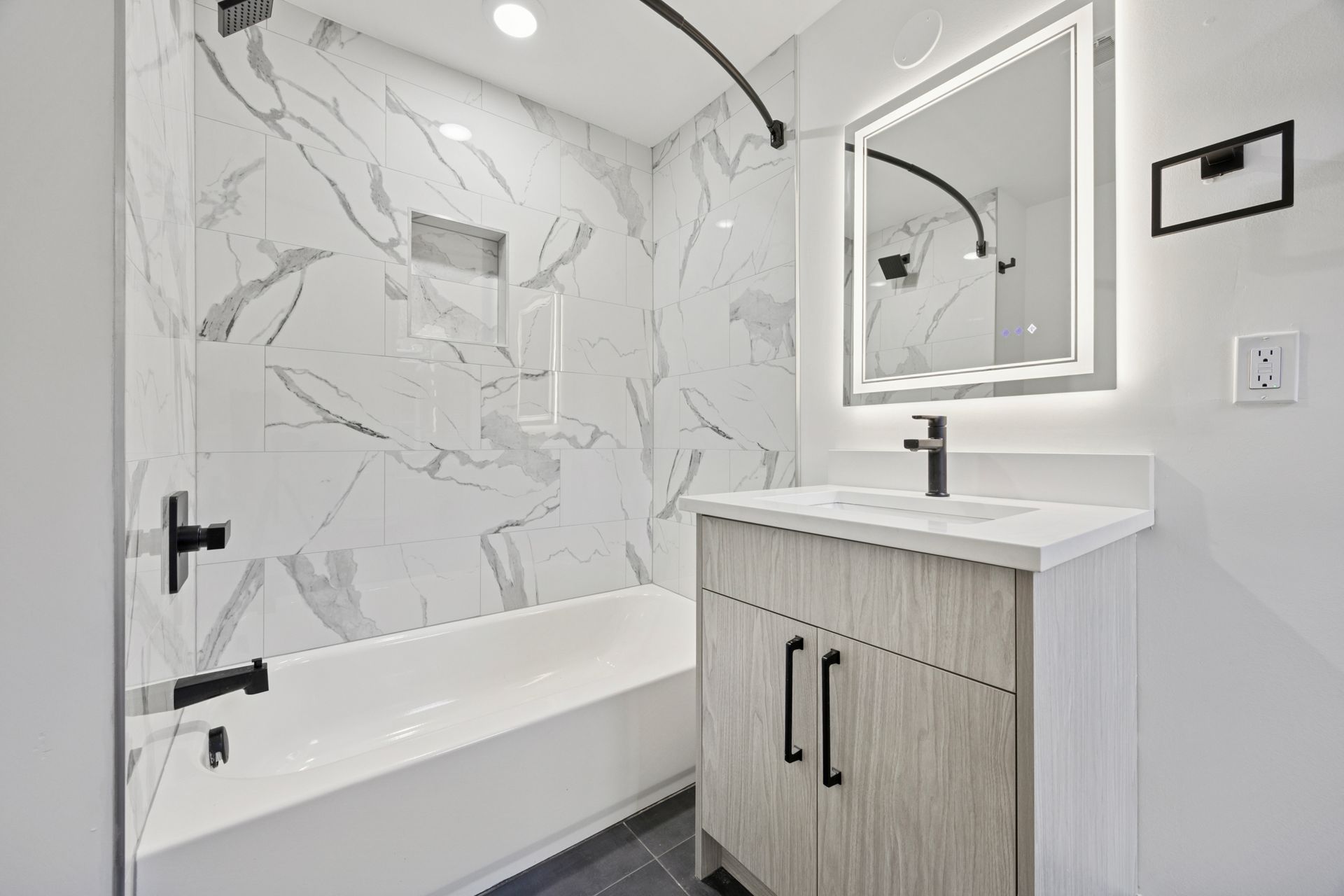Updated bathroom with marble-style tile and vanity at 6399 Drexel Road apartment West Philadelphia