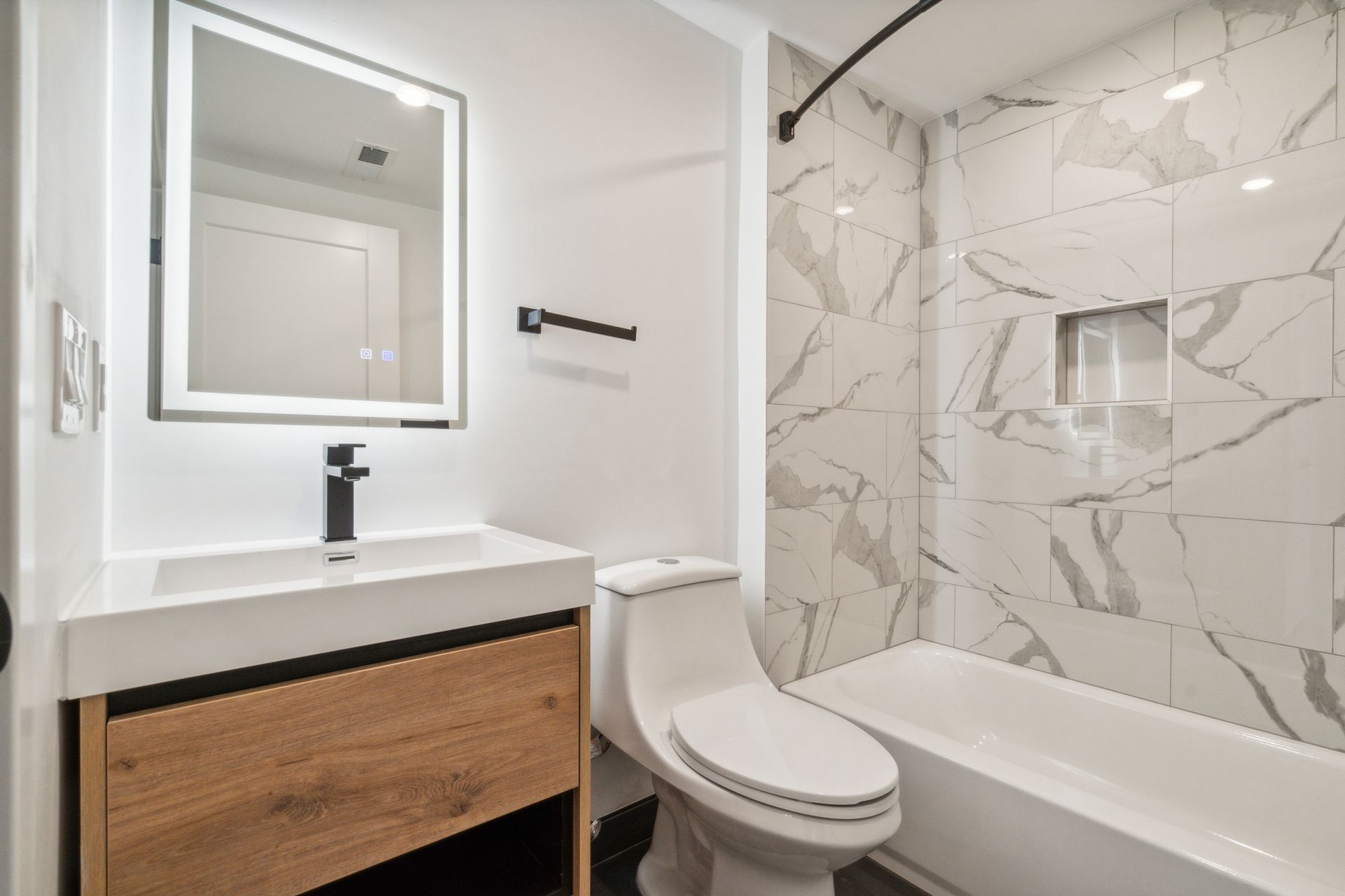 Updated bathroom with marble-style tile and vanity at 881 N 40th St apartment West Philadelphia