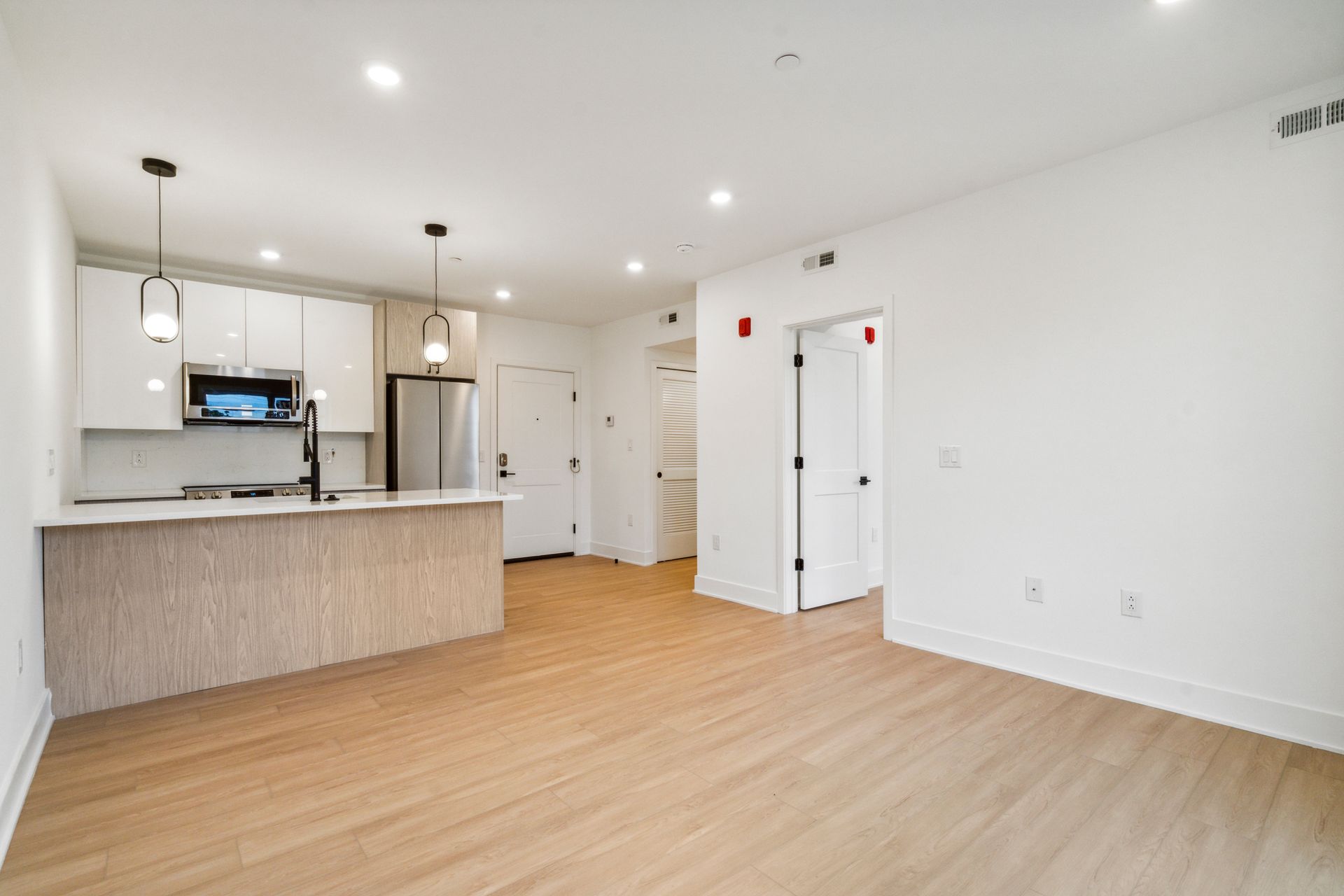 Open kitchen and living area with updated appliances at 881 N 40th St West Philly apartment