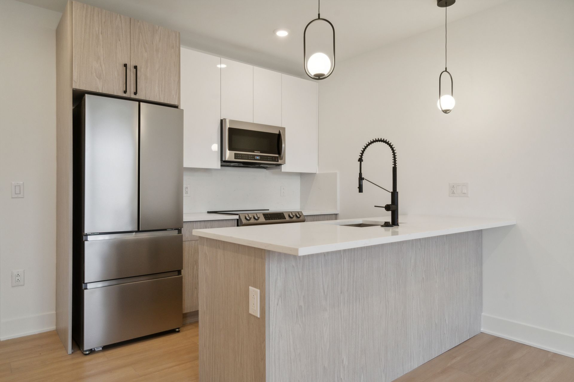 Open kitchen and living area with updated appliances at 881 N 40th St West Philly apartment
