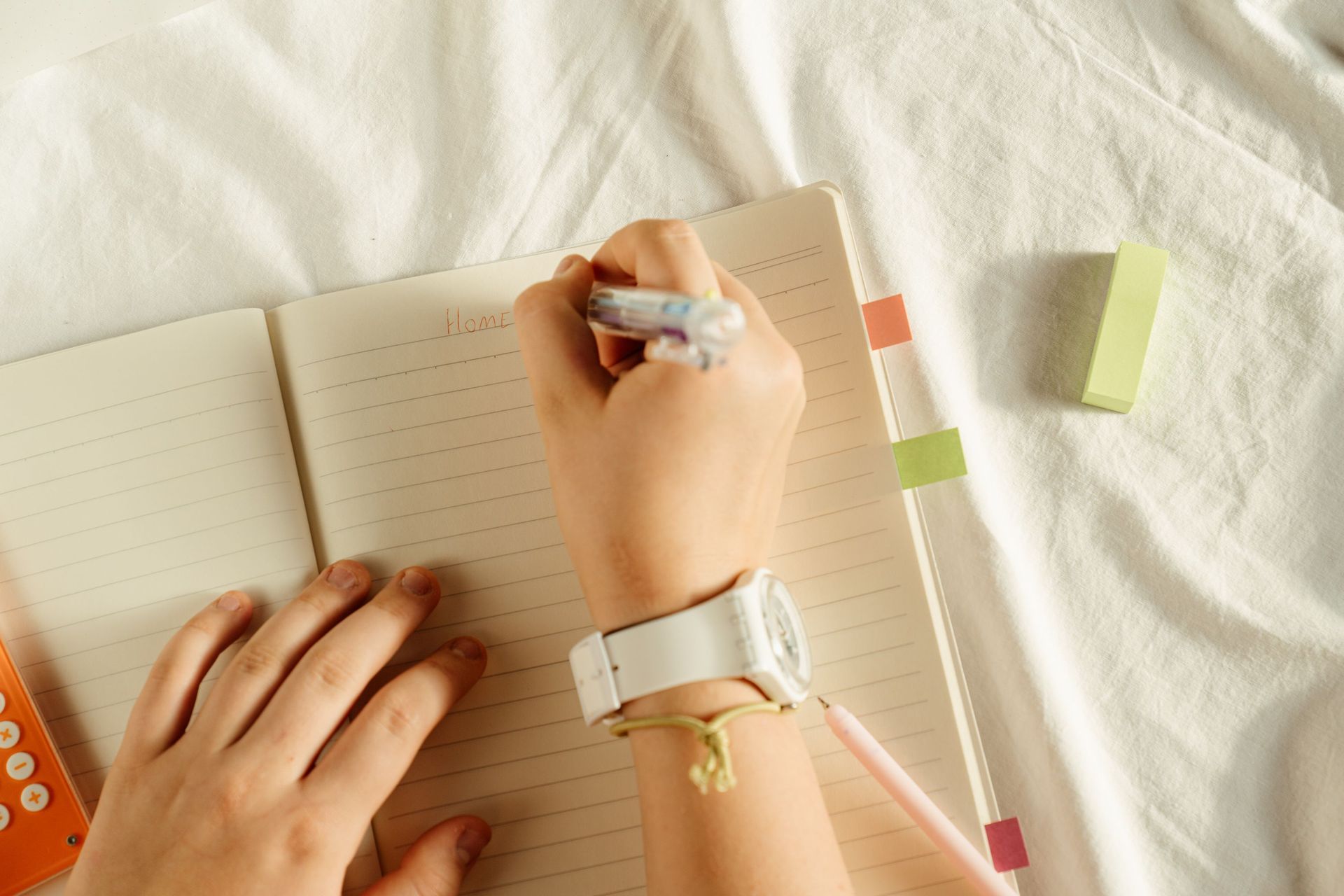 white background, book, writing in journal, green eraser 