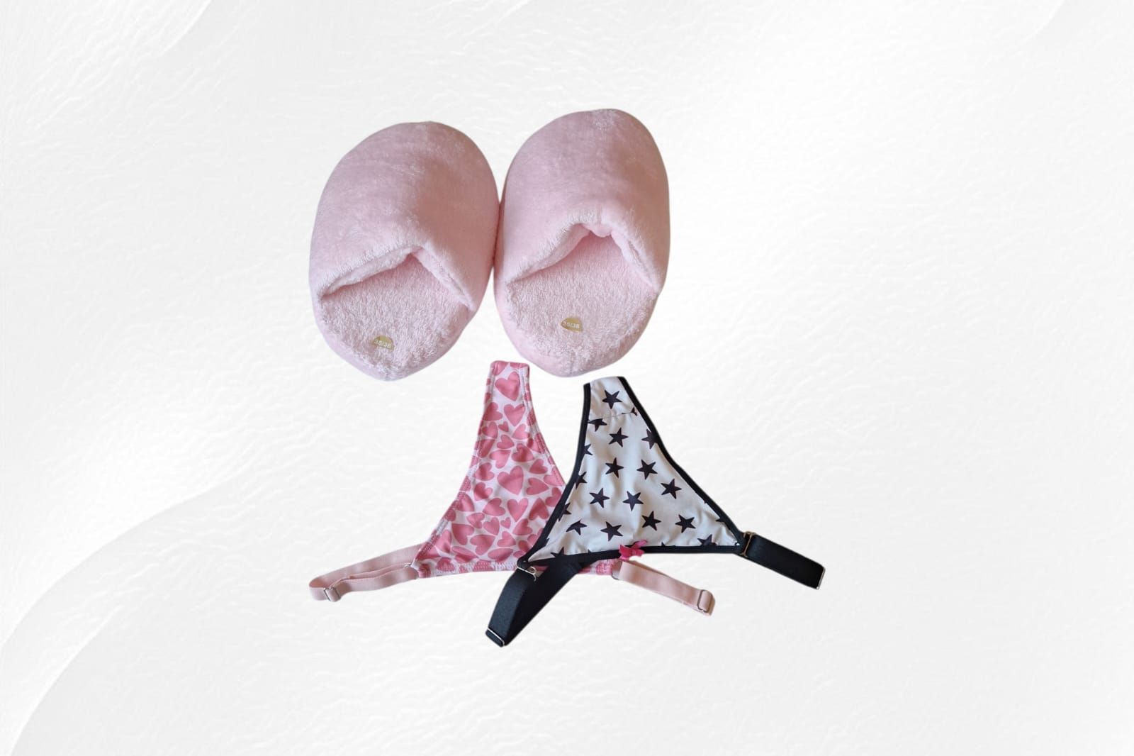 Zapatos de bebé rosas y calcetines estampados sobre un fondo blanco.